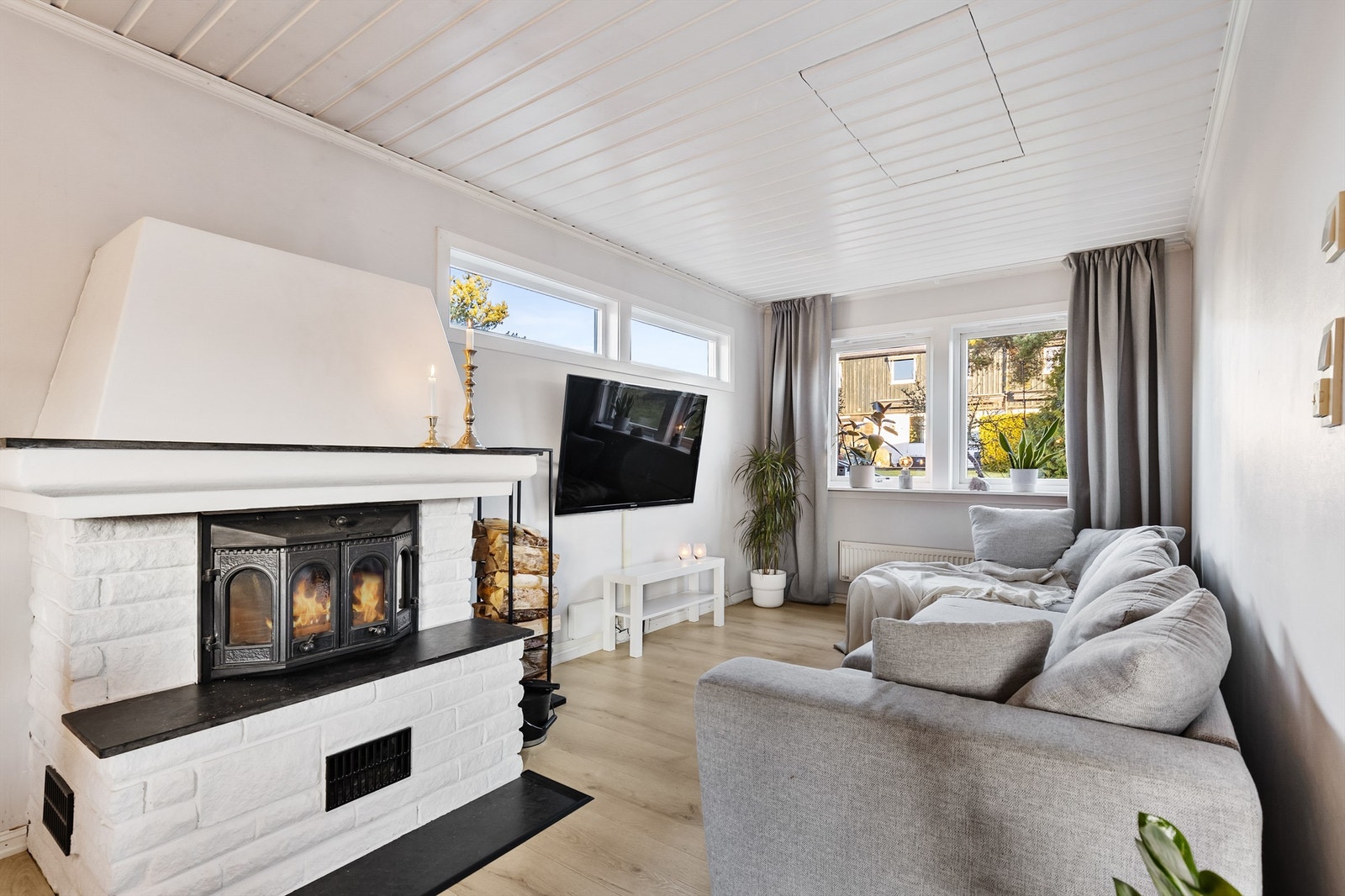 En egen del av stuen er tilrettelagt som en hyggelig TV-krok. Peisovnen skaper en lun atmosfære og gir god varme på kalde dager. Galleribilde