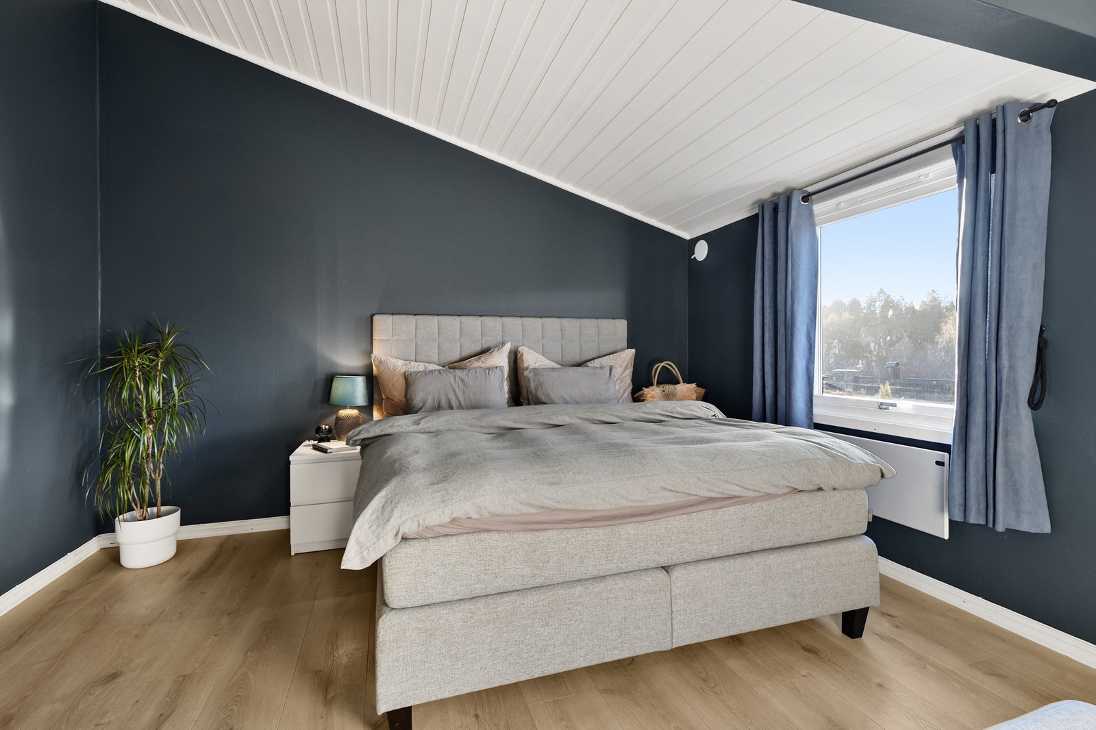 Hovedsoverommet har en behagelig atmosfære med mørke veggflater og skråtak. Galleribilde