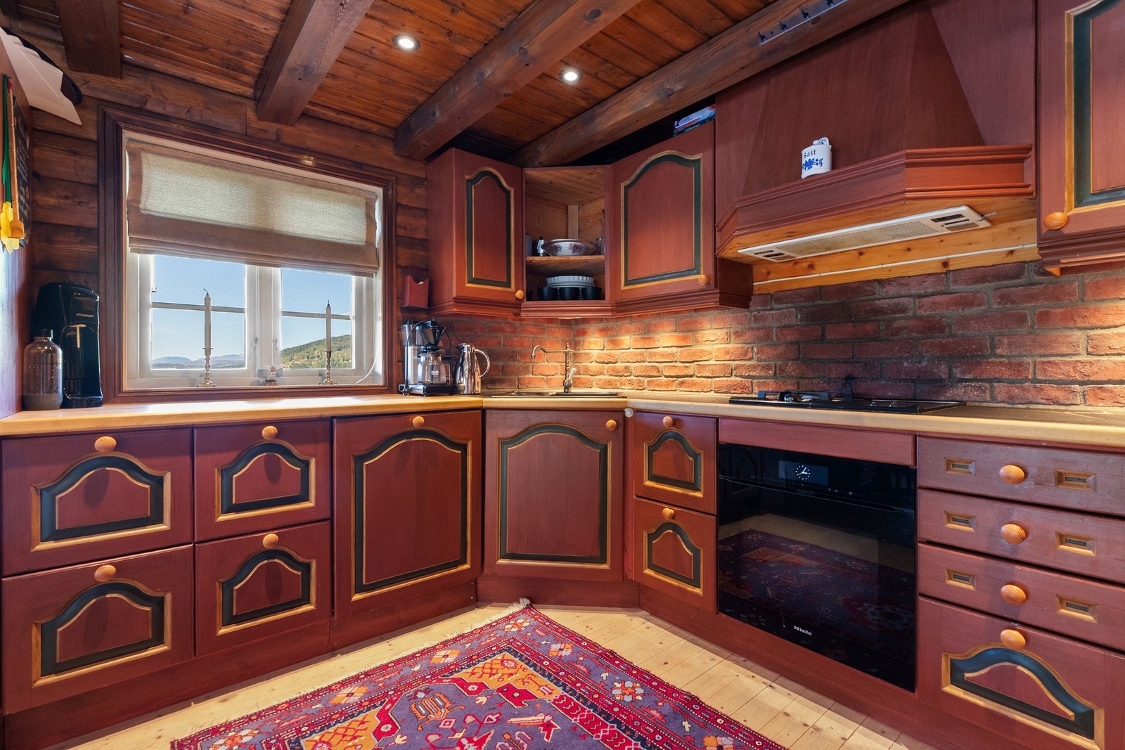 Rikelig med skapplass og benkeplate av heltre og skifer. Koketoppen har 2 gassbluss og en elektrisk. Integrert kjøl/frys og oppvaskmaskin, stekeovn i sort utførelse Galleribilde