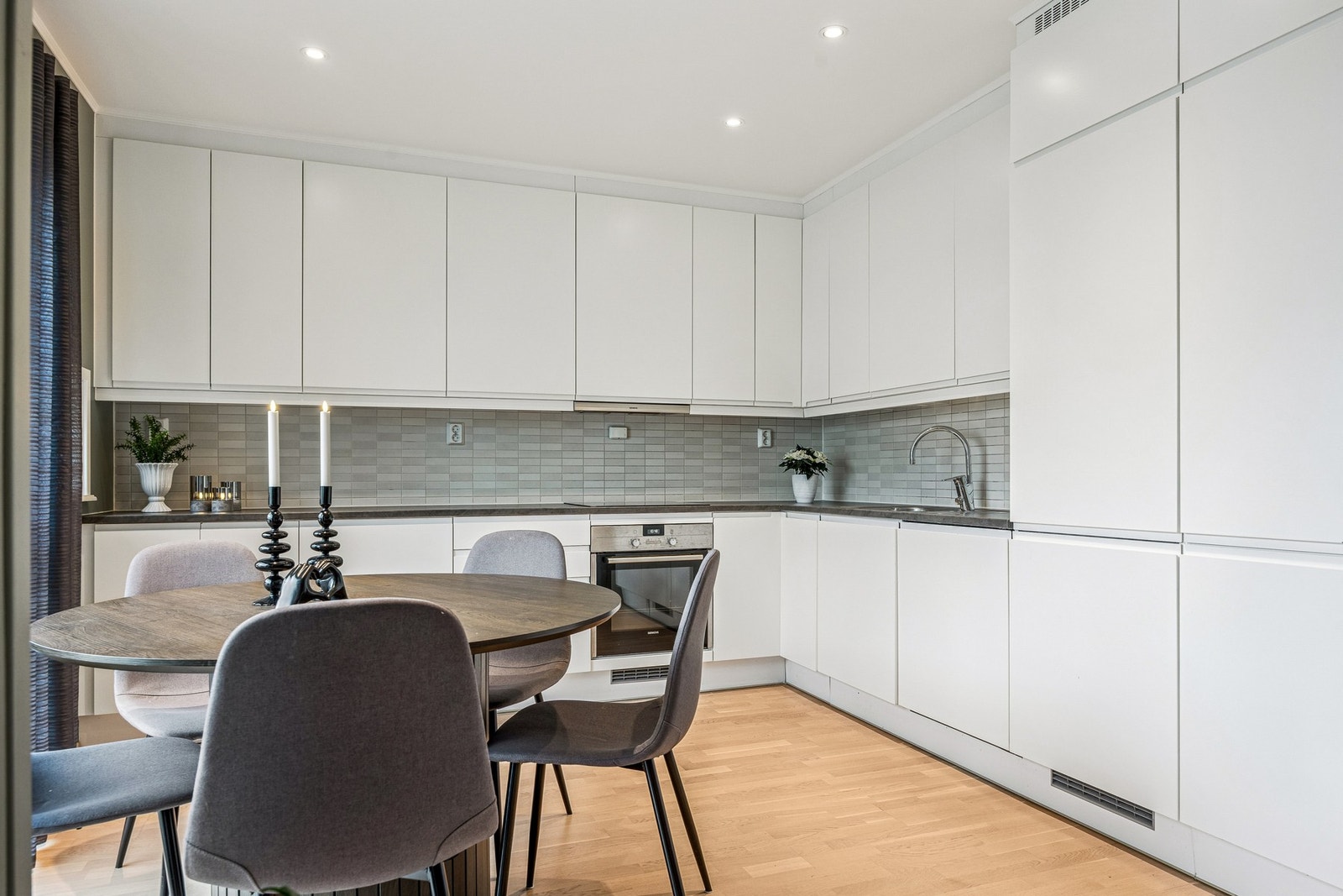 Kjøkkenet har en moderne og tidløs utforming med innredning fra byggeår, glatte fronter og laminat benkeplate, og er vurdert til tilstandsgrad TG1 fra takstmann. Galleribilde