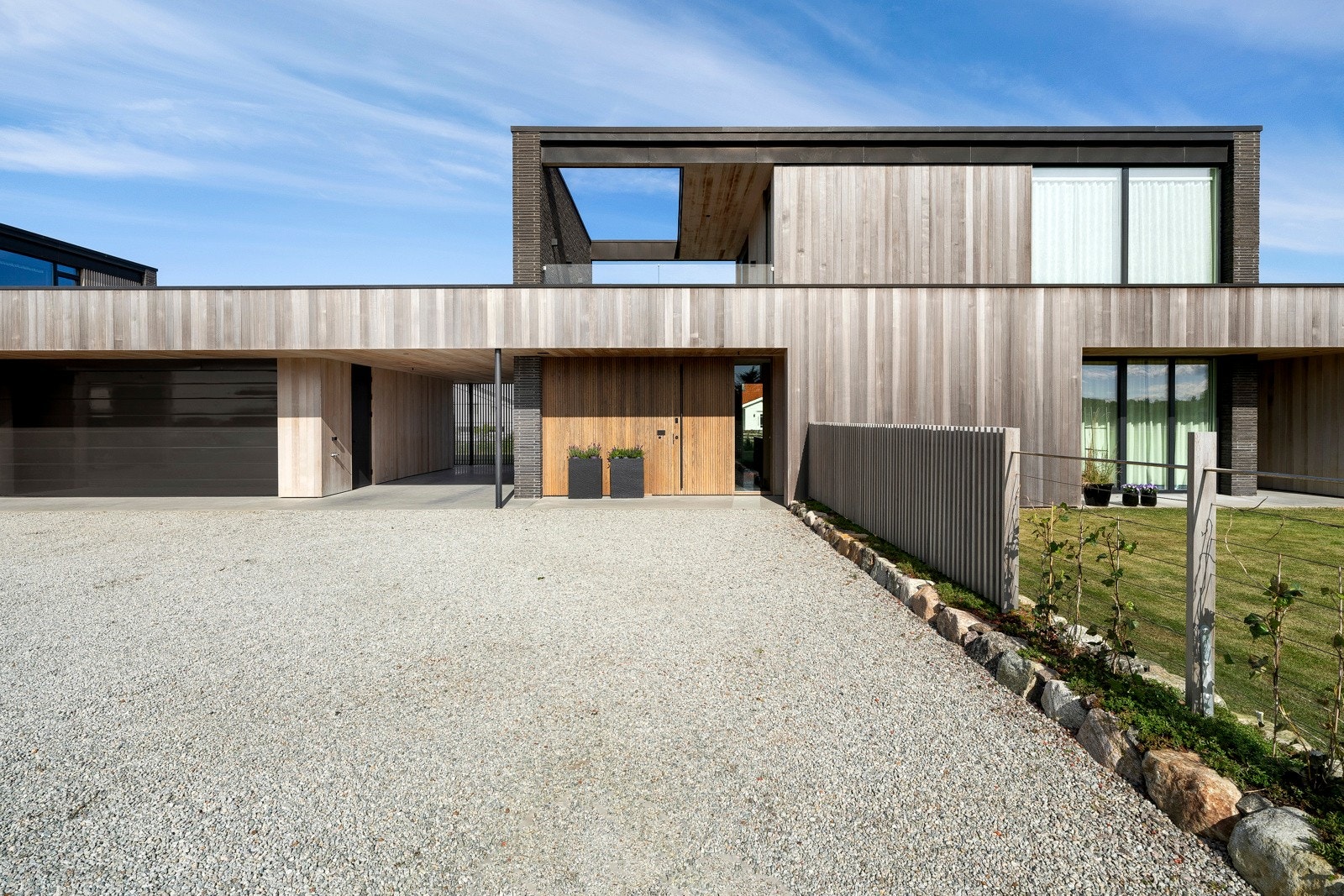 Boligen er delt i to bygningskropper, tilknyttet av dobbelgarasje med verksted i midtpartiet. Galleribilde