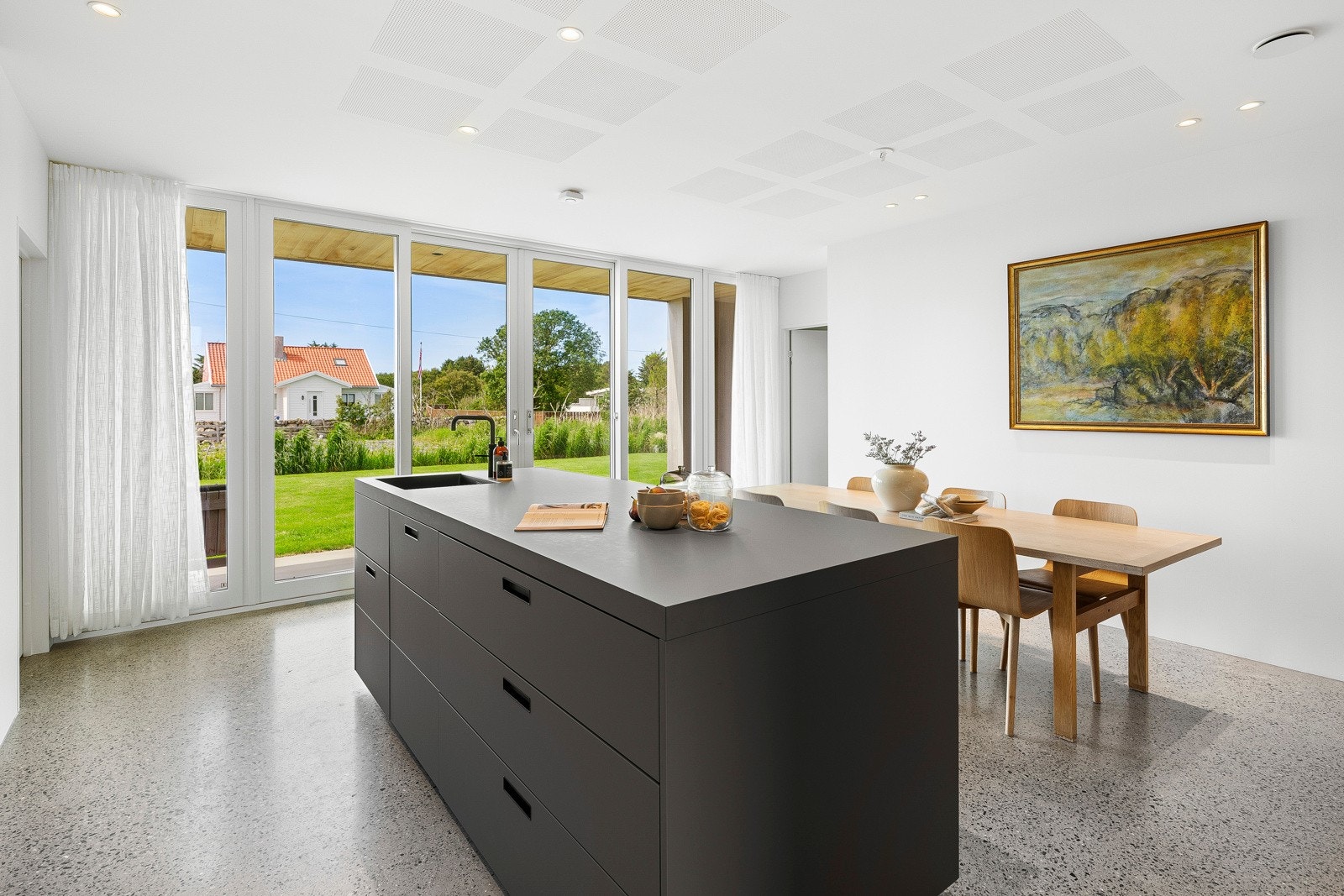 Øya har sort benkeplate i matt laminat og benken har benkeplate i heltre som matcher frontene. Høyskap, veggskap og benkeskap med glatte eikefronter er laget av møbelsnekker. Galleribilde