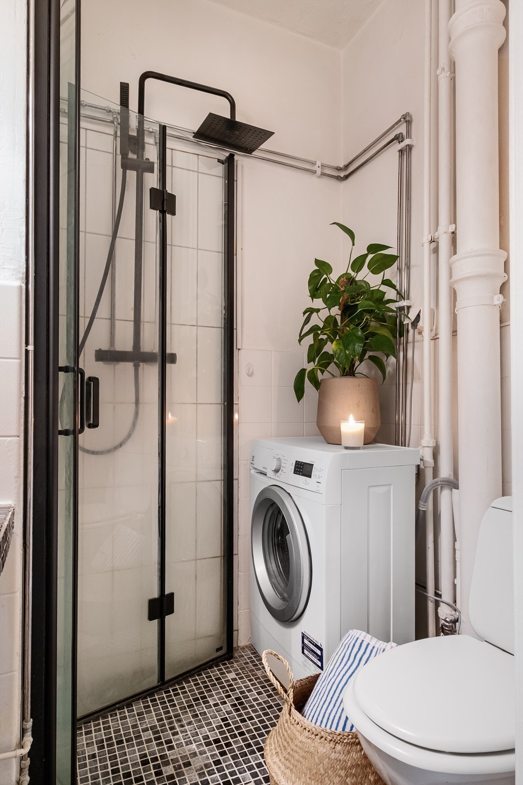 Badet er innredet med gulvstående toalett, servant, speil og dusjvegger. Her er det naturlig avtrekk, og opplegg for vaskemaskin. Galleribilde