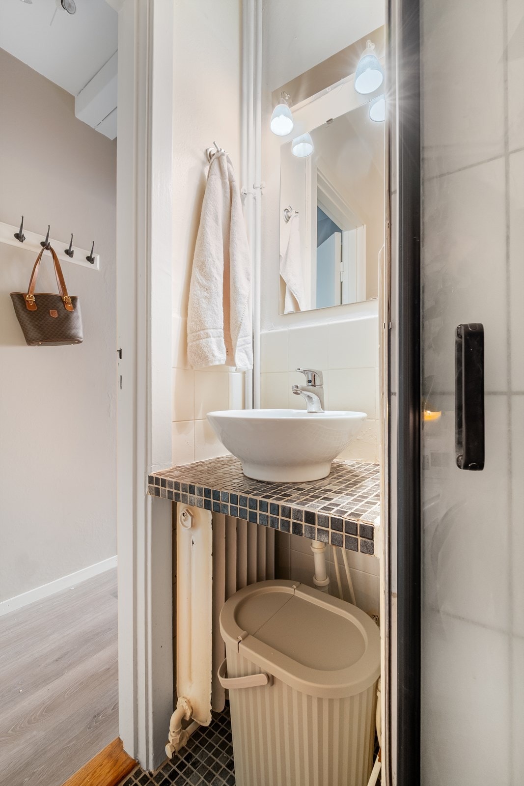 Flislagt bad med pene mosaikkfliser på gulvet og under servanten. Galleribilde