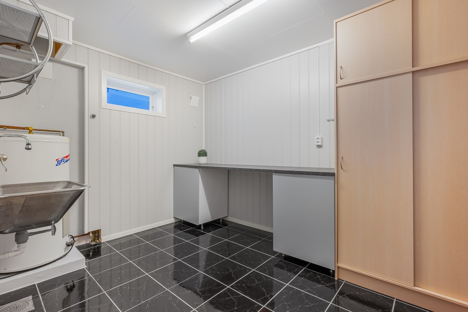 Ved siden av badet ligger det et kombinert vaskerom og teknisk rom som ble pusset opp i 2016. Også her er det flislagt gulv med gulvvarme og innredning med garderobeskap, vaskekum, opplegg
for vaskemaskin og varmtvannsbereder. Galleribilde