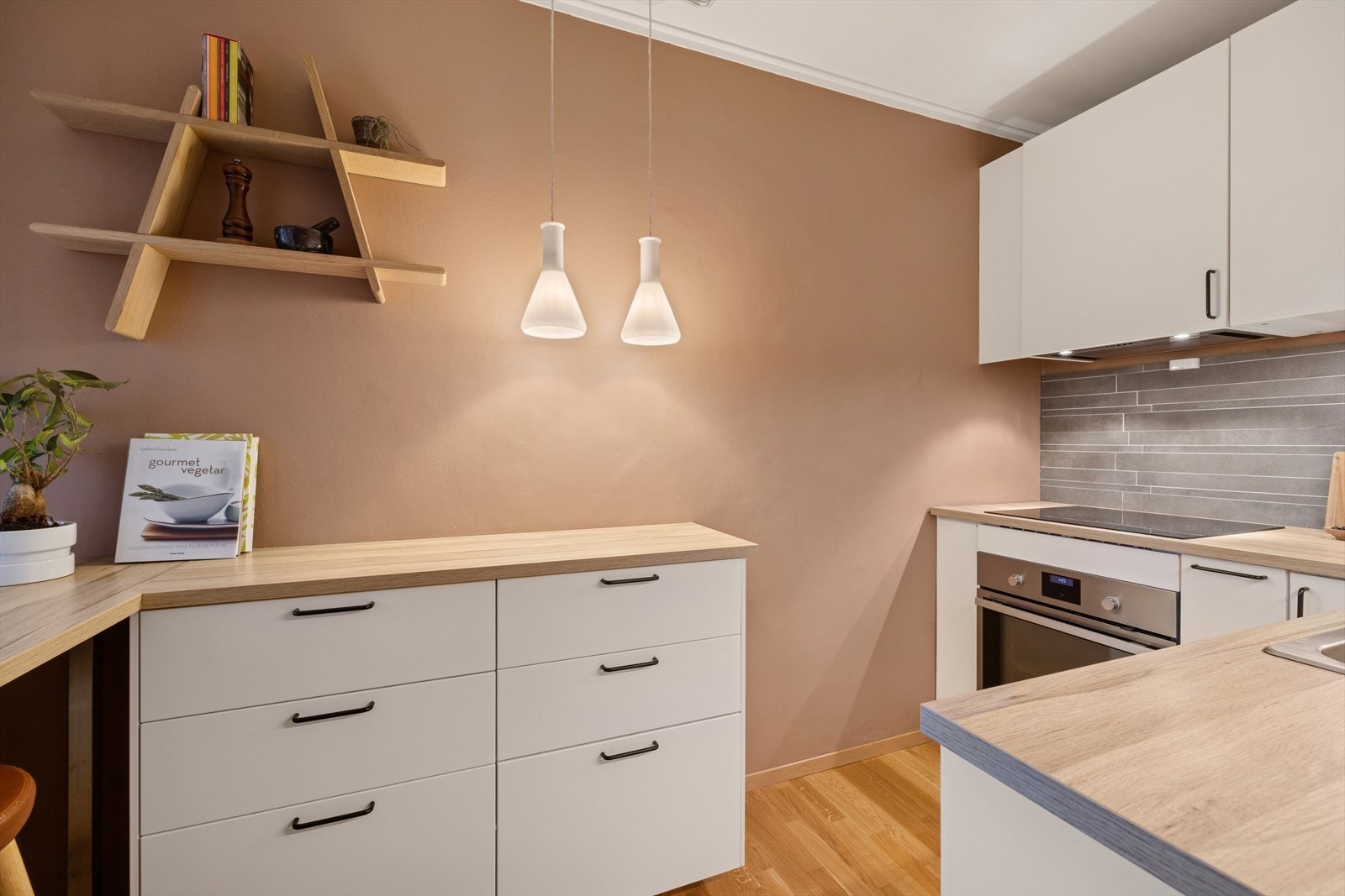 Kjøkkenet fremstår som lyst og pent med Ikea-innredning i tidløst design fra 2018/2019. De glatte, hvite frontene gir et rent og elegant uttrykk, mens benkeplatene i laminat kombinerer funksjonalitet med et moderne preg. Galleribilde