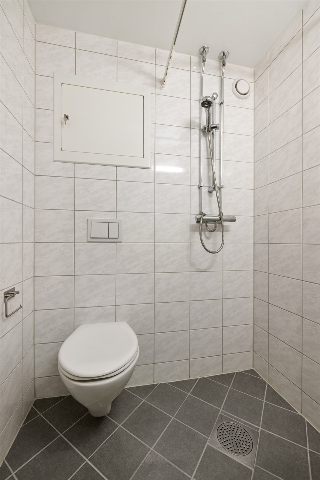 Innredningen består av et vegghengt toalett samt en praktisk servant med tilhørende armatur, speil og belysning. Dusjsonen er utstyrt med dusjforheng og et helt nytt dusjbatteri fra 2024 - en detalj som gir ekstra trygghet og kvalitet. Varmekabler i gulv Galleribilde