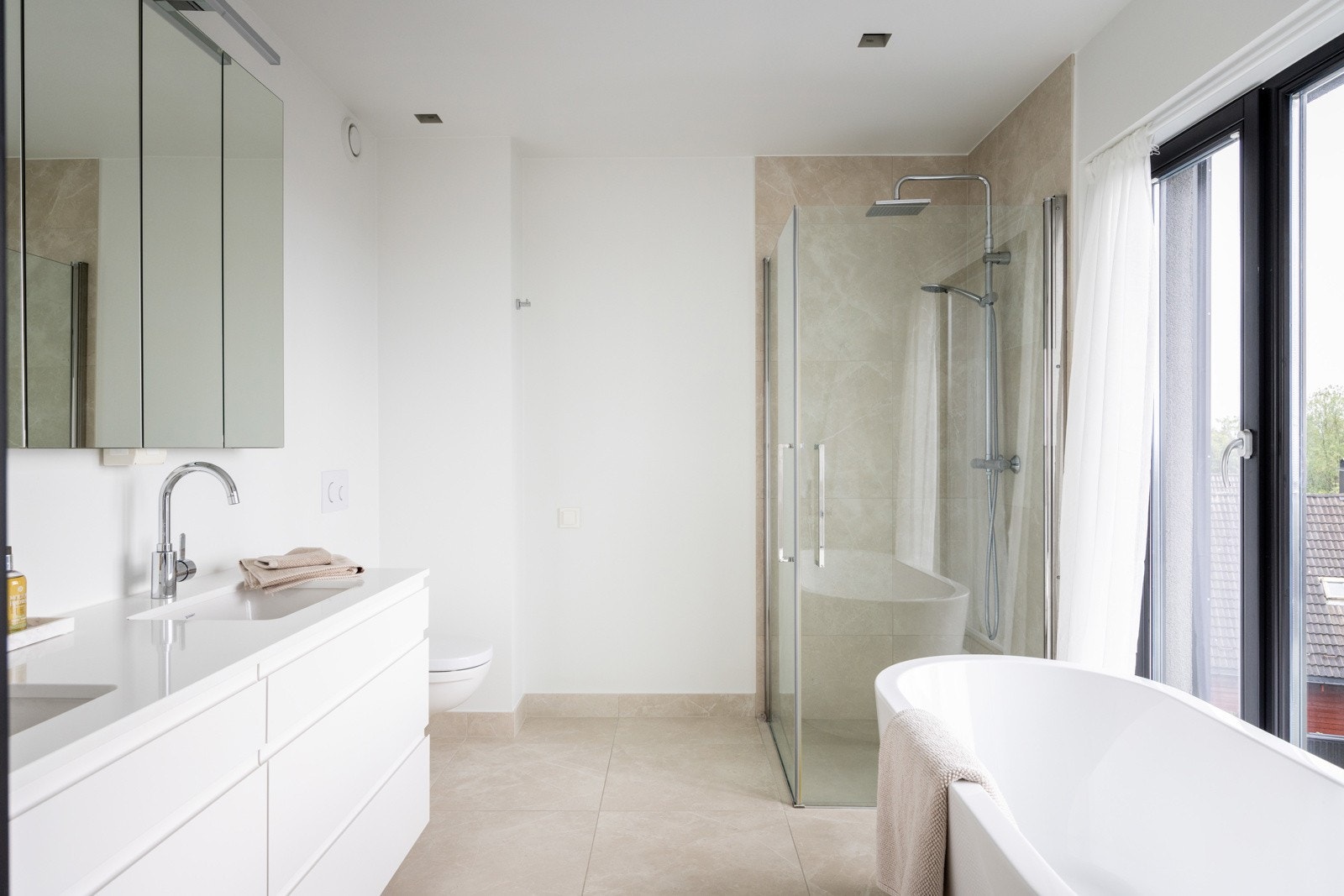 Badet fremstår moderne og innbydende med fliser på gulv, kombinasjon av fliser og plater på vegger samt malte plater i taket. Galleribilde