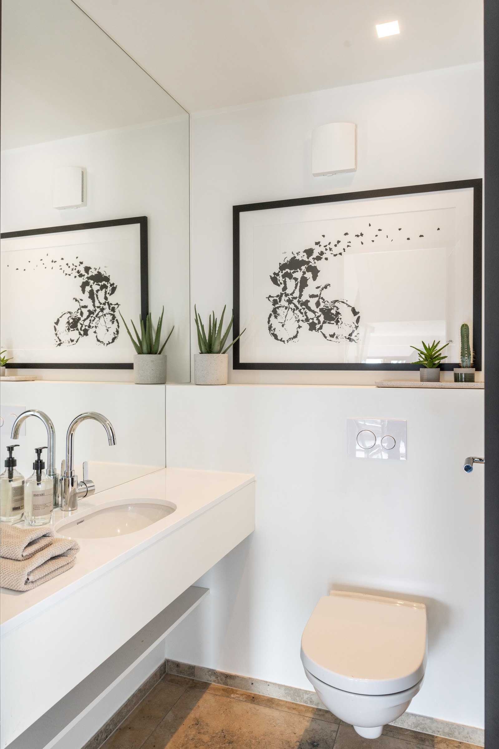 Innredet med veggmontert toalett og servant i innredning. Galleribilde