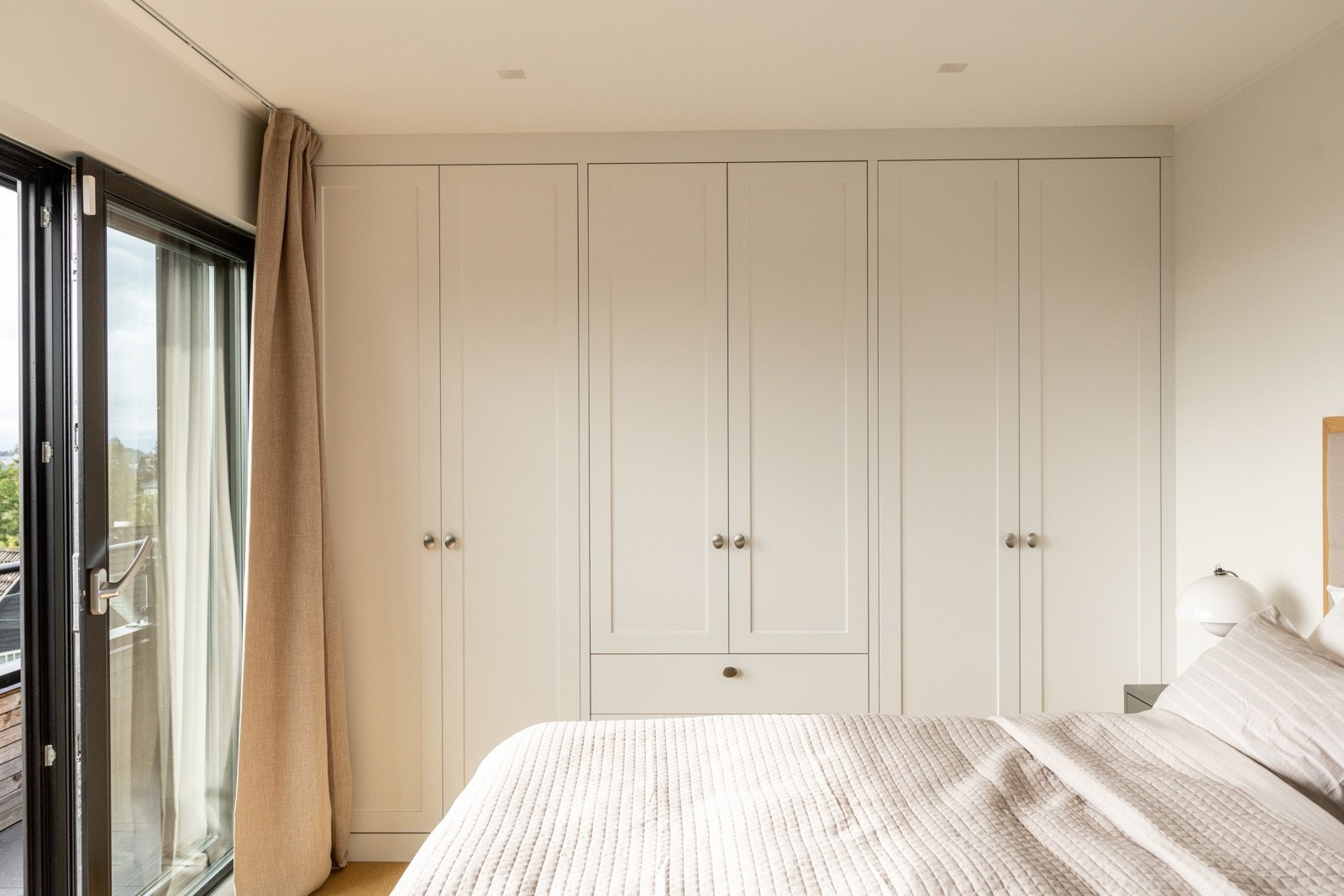 Plassbygget garderobe fra JH Interiør som gir rikelig oppbevaringsplass og et gjennomført helhetlig uttrykk. Galleribilde