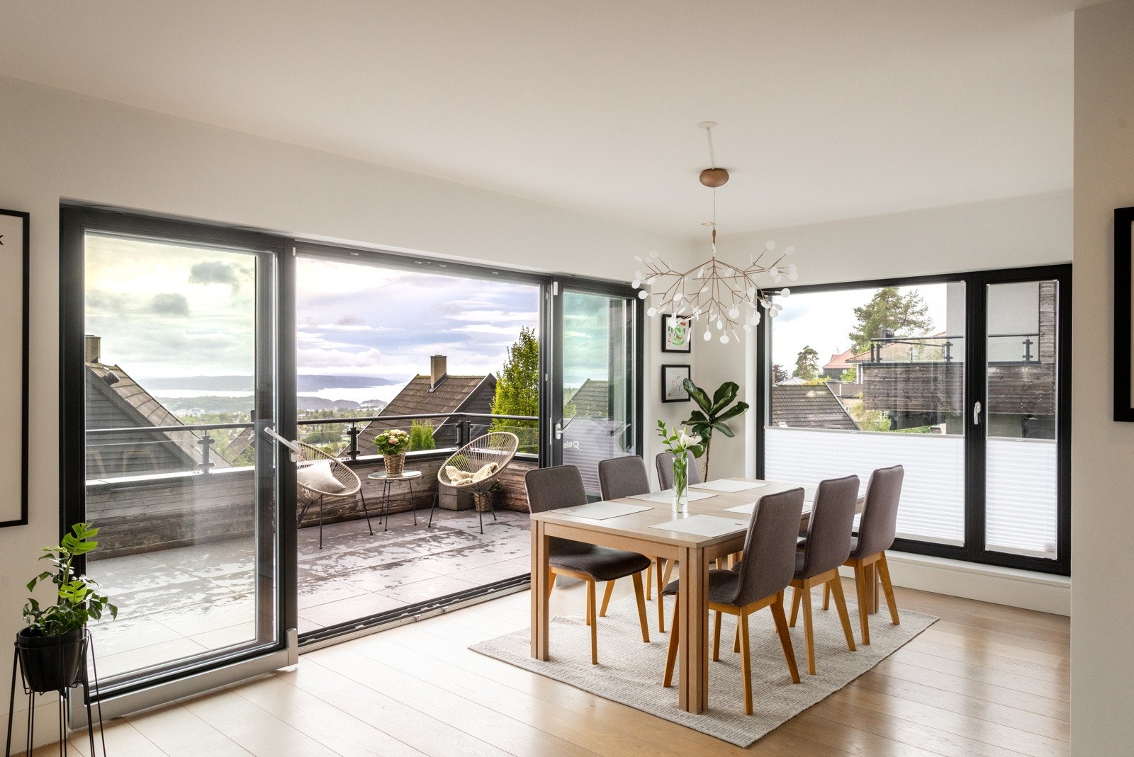 Store vindusflater bidrar med naturlig lys og skaper en hyggelig atmosfære, samtidig som kjøkkenet har en fin kontakt med spiseplassen og stuen. Galleribilde