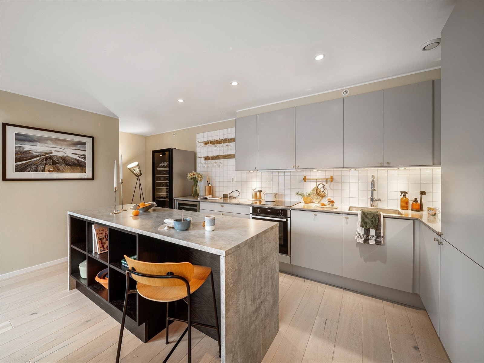 Praktisk kjøkkenøy med god skapplass og spesialbygget hylle (sortbeiset eik fra Minde Snekkeri). Benkeplate i laminat på kjøkkenøy. Galleribilde