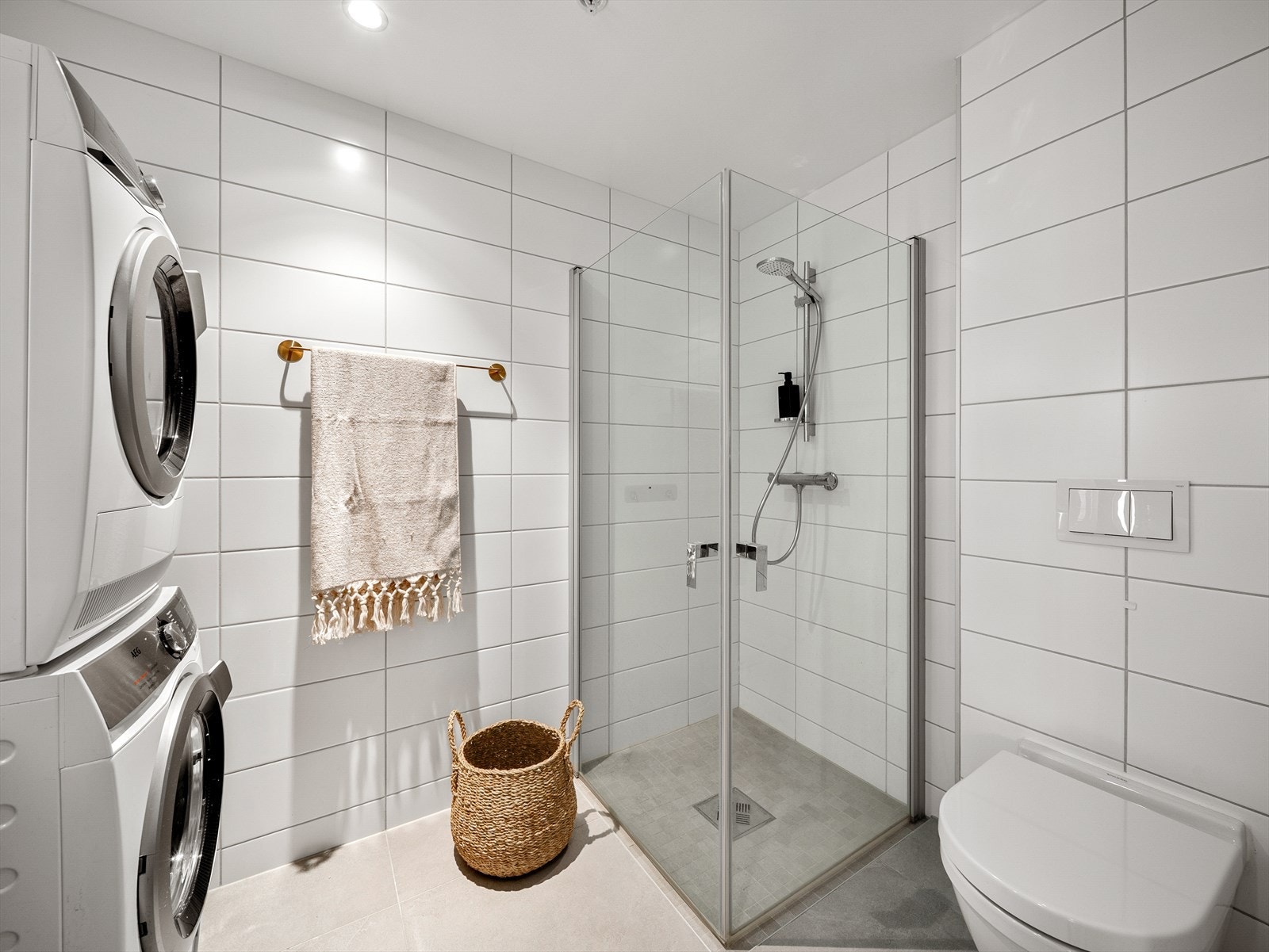 Badet i 1. etasje er helfliset og inneholder baderomsinnredning, dusjhjørne og vegghengt toalett. Galleribilde