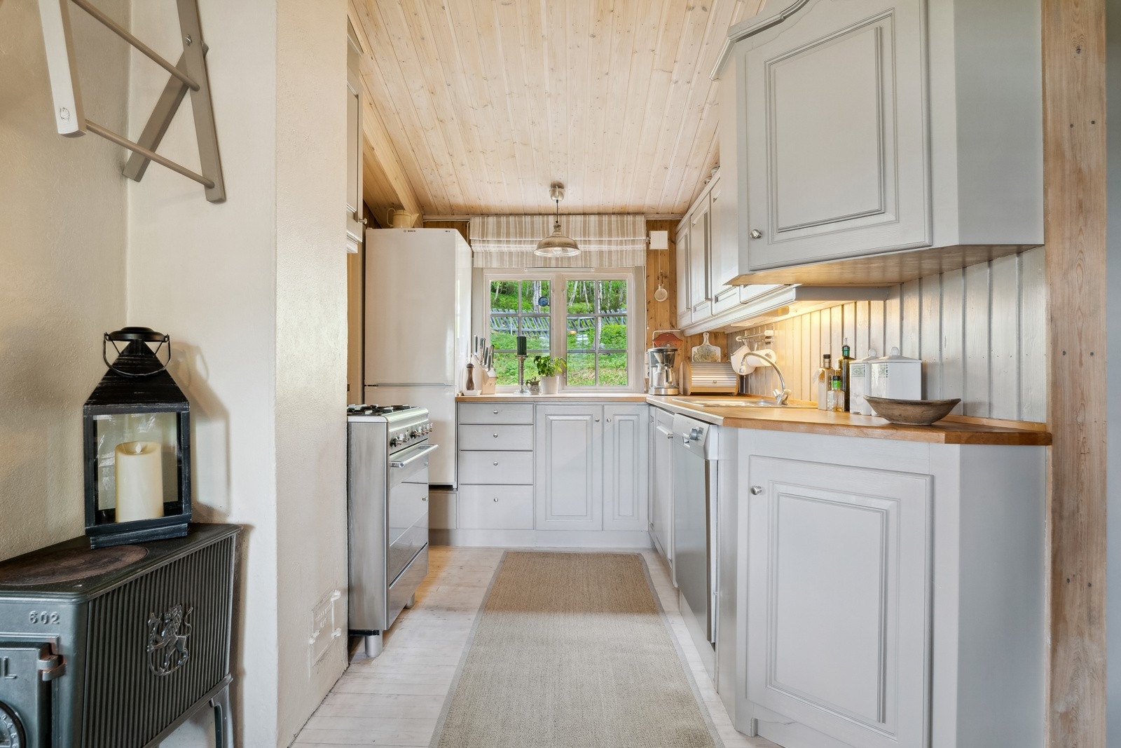 Kjøkkeninnredningen i hoveddelen er fra 2010, med lyse, profilerte fronter, benkeplate i heltre og gasskomfyr. Det er også installert oppvaskmaskin, og kjøle- og fryseskap. Galleribilde