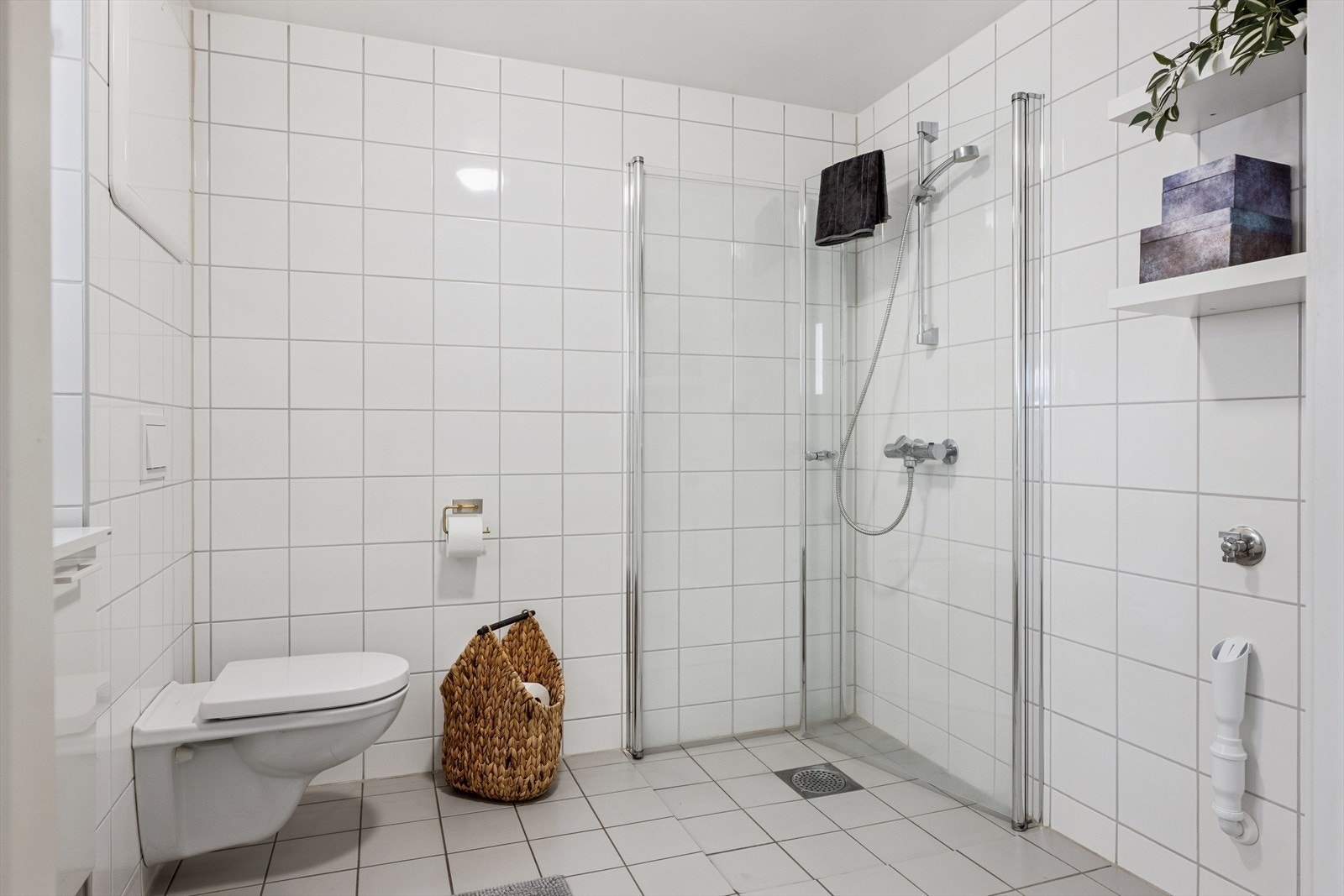 Flislagt bad med vannbåren gulvvarme. Vegghengt toalett og opplegg for vaskemaskin. Galleribilde