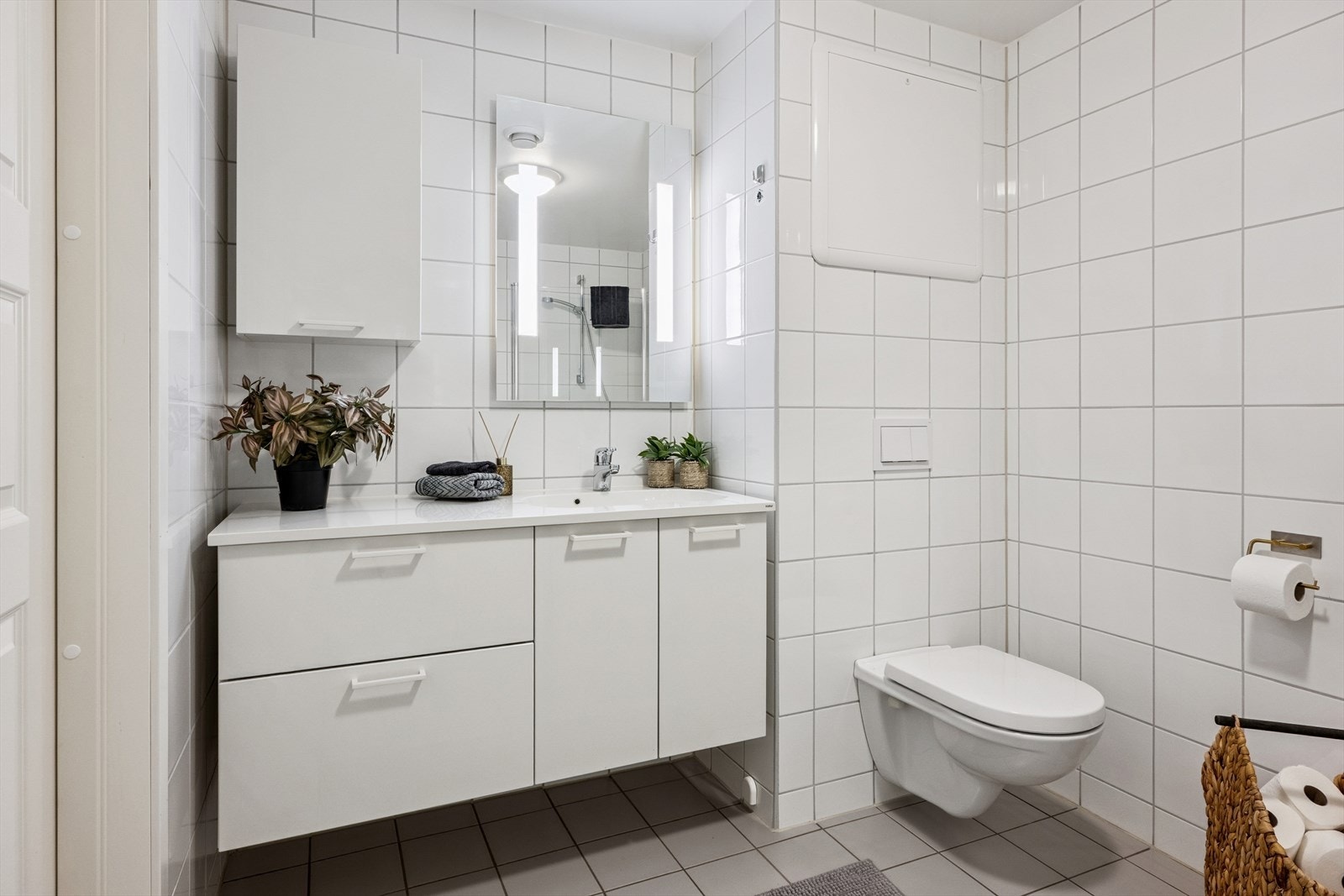 Rommet har innredning med heldekkende servant, veggmontert toalett og opplegg for vaskemaskin. Dusjsone med glassdører. Galleribilde