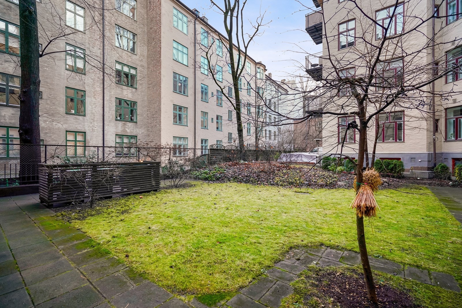 Gårdsrommet er pent opparbeidet med plen, beplantning, trær og gangstier. Galleribilde