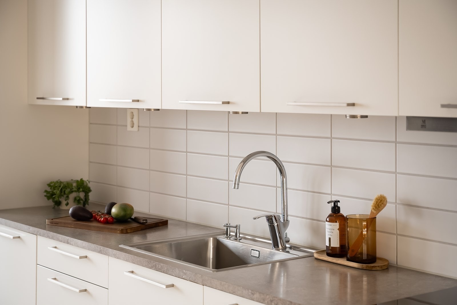 Kjøkkenet fremstår som lyst og har en moderne standard med fliser på vegg over benkeplaten. Galleribilde