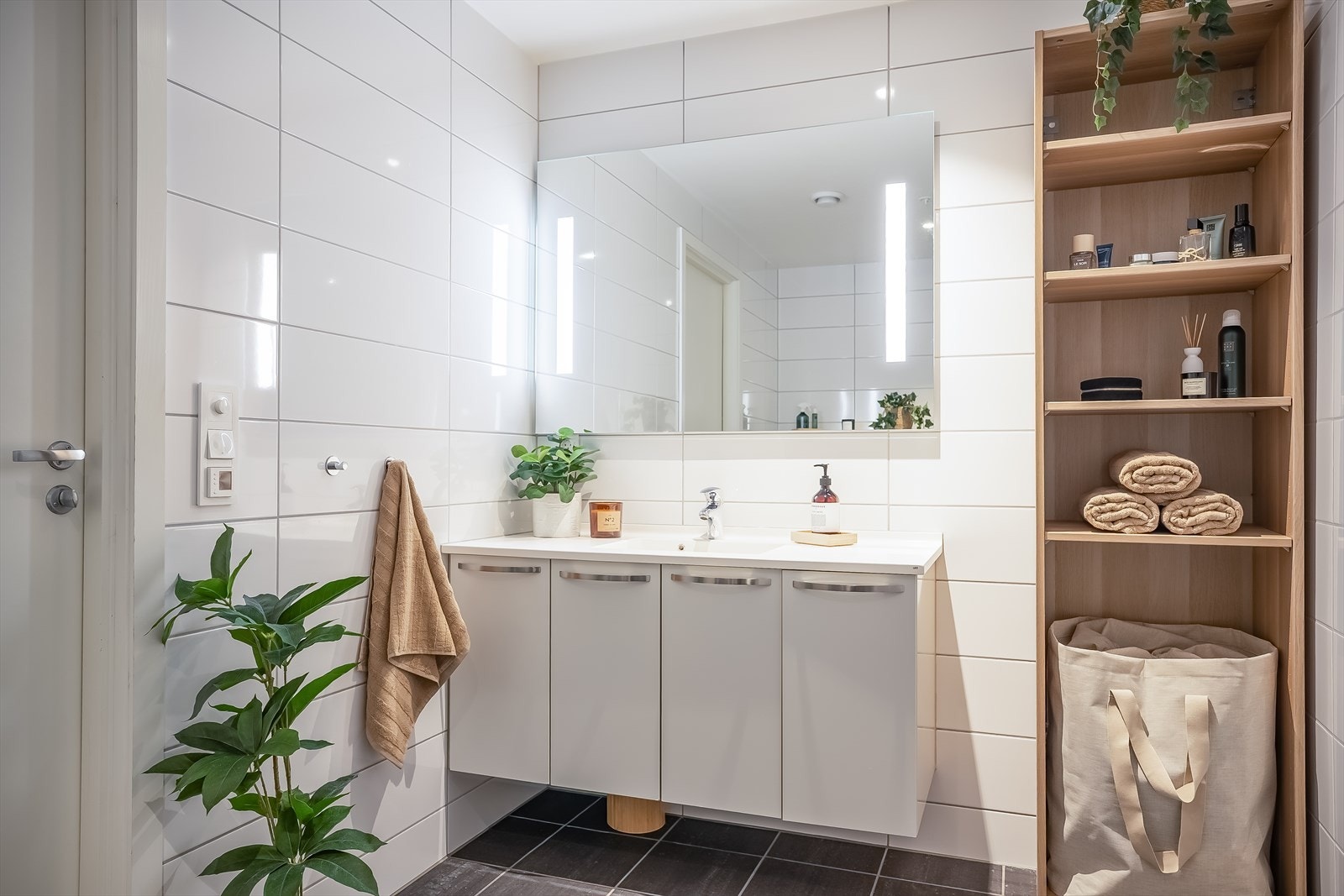 Flott flislagt bad på 6,3 m² med god skapplass i servantinnredningen og speil med innfelte lys. Galleribilde