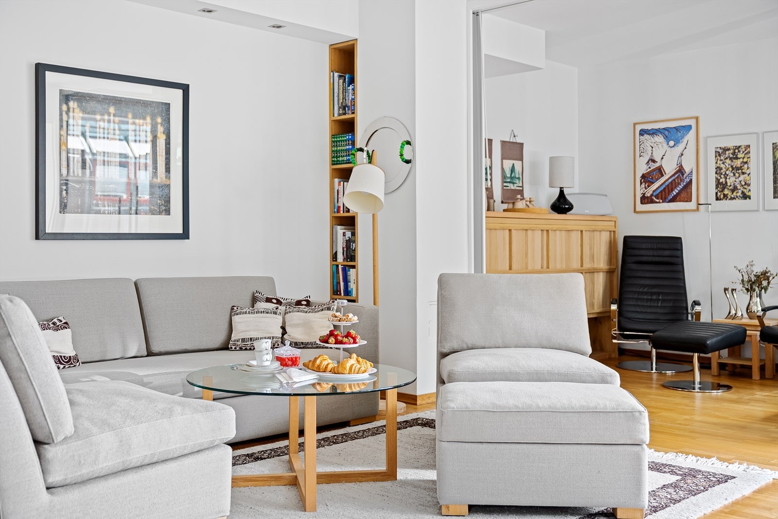 Det er gjennomgående parkettgulv i alle rom, foruten på badene hvor det er fliser. Forøvrig er det slette malte vegger og himlinger. Legg merke til den stilige innebygde hyllen og den ellers gode belysningen med downlights i stuen. Galleribilde