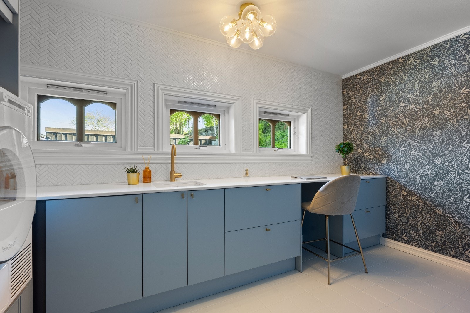 Stort og moderne vaskerom, pusset opp i 2023, med flislagt gulv og stilren innredning. Slette flater gir rikelig med lagringsplass og gode arbeidsflater. Galleribilde