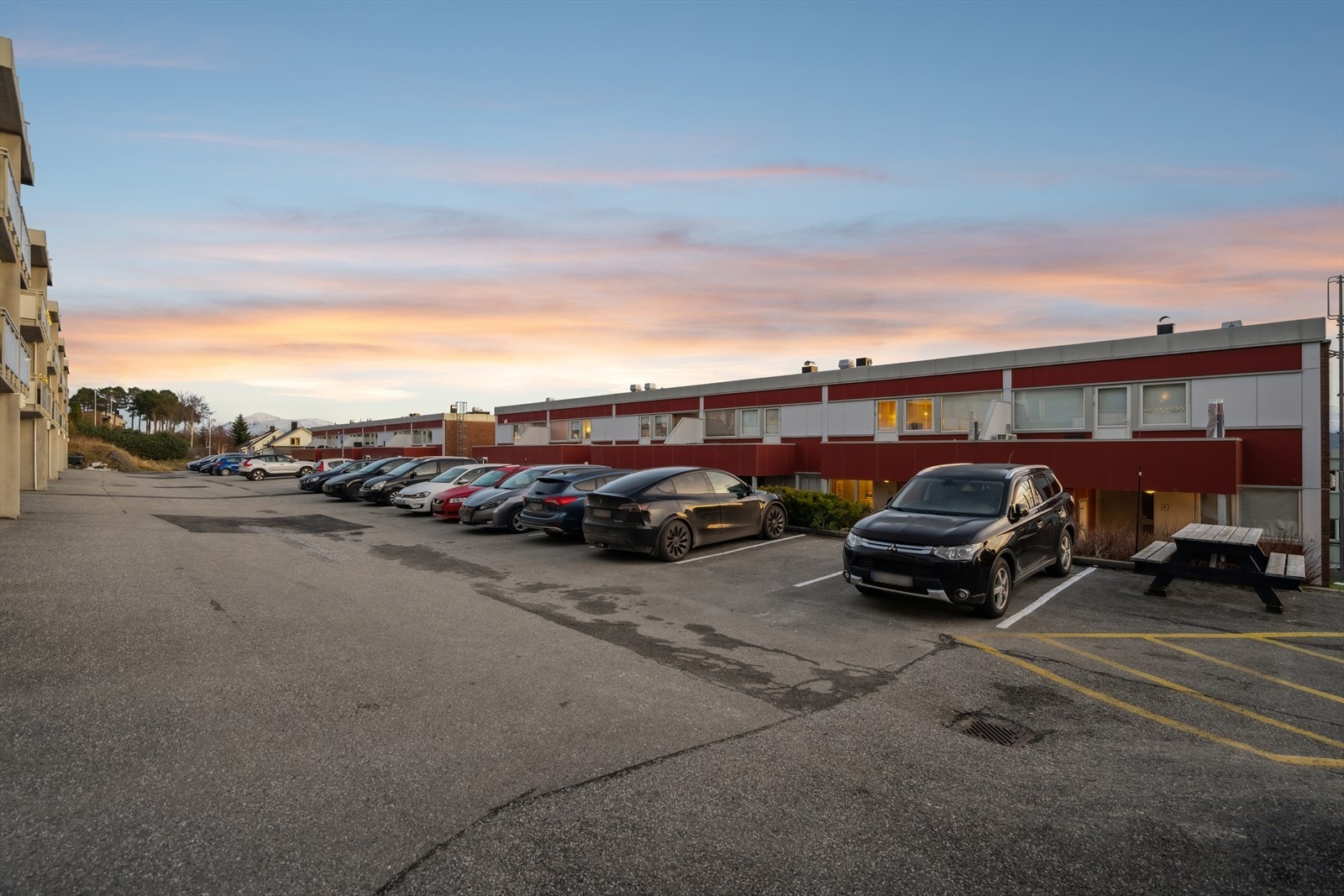 Felles parkeringsplass mellom blokkene gir praktisk parkering for beboere. Galleribilde