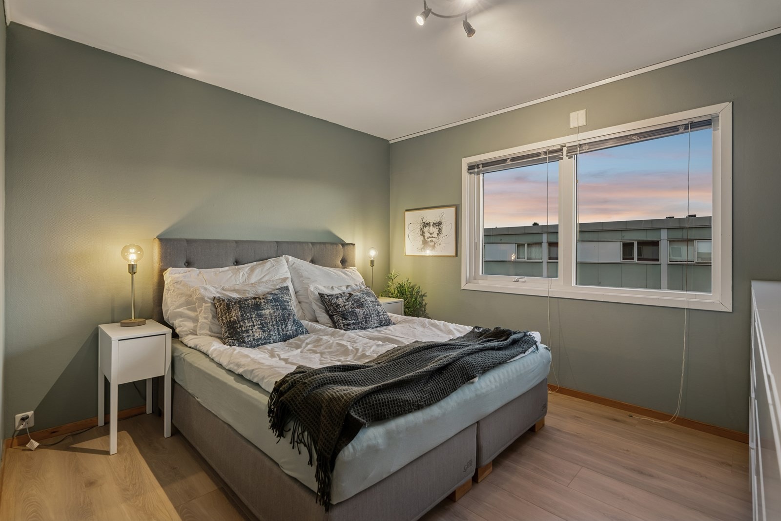 Laminatgulv og malte vegger gir et moderne uttrykk i soverommet. Galleribilde