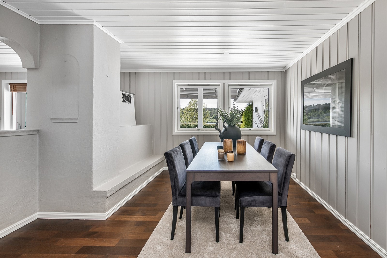 Et større spisebord finner sin naturlige plass foran innredning ved vindu Galleribilde