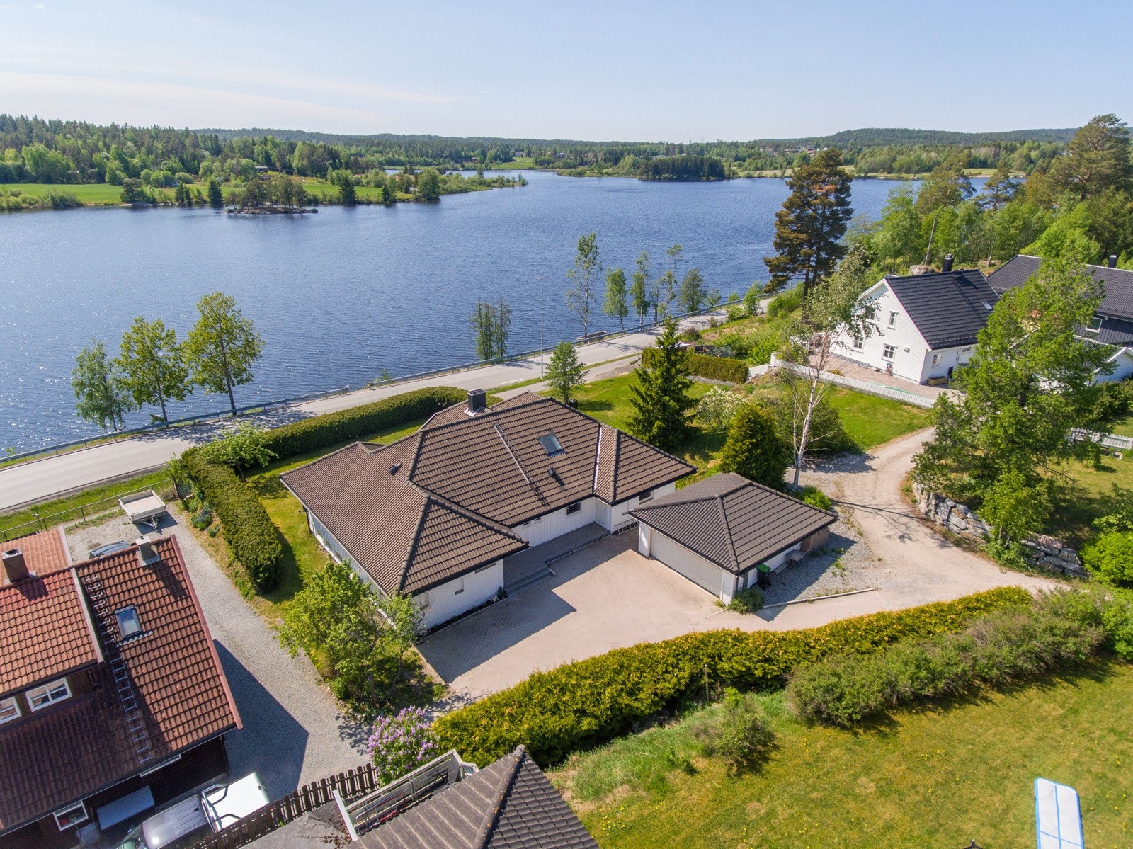 Stensatt gårdsplass og romslig dobbelgarasje som er bygget i samme stil som boligen Galleribilde