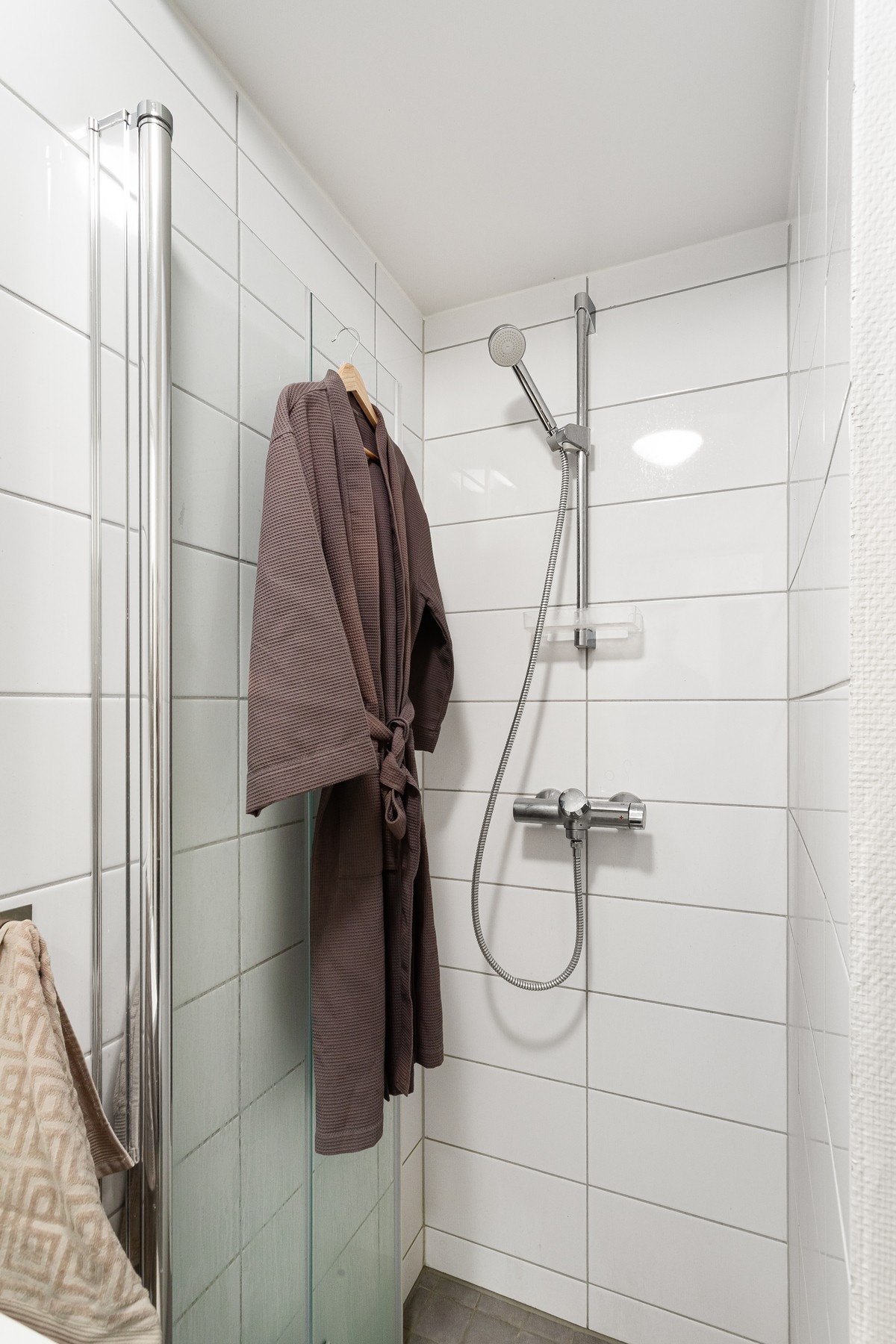 Dusjsone med flislagte vegger og glassvegger som gir et ryddig og praktisk baderom. Galleribilde