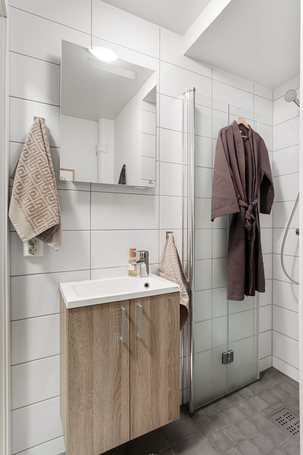 Badet er utstyrt med servant med underskap. Flislagte overflater gir et rent og lettstelt uttrykk. Galleribilde