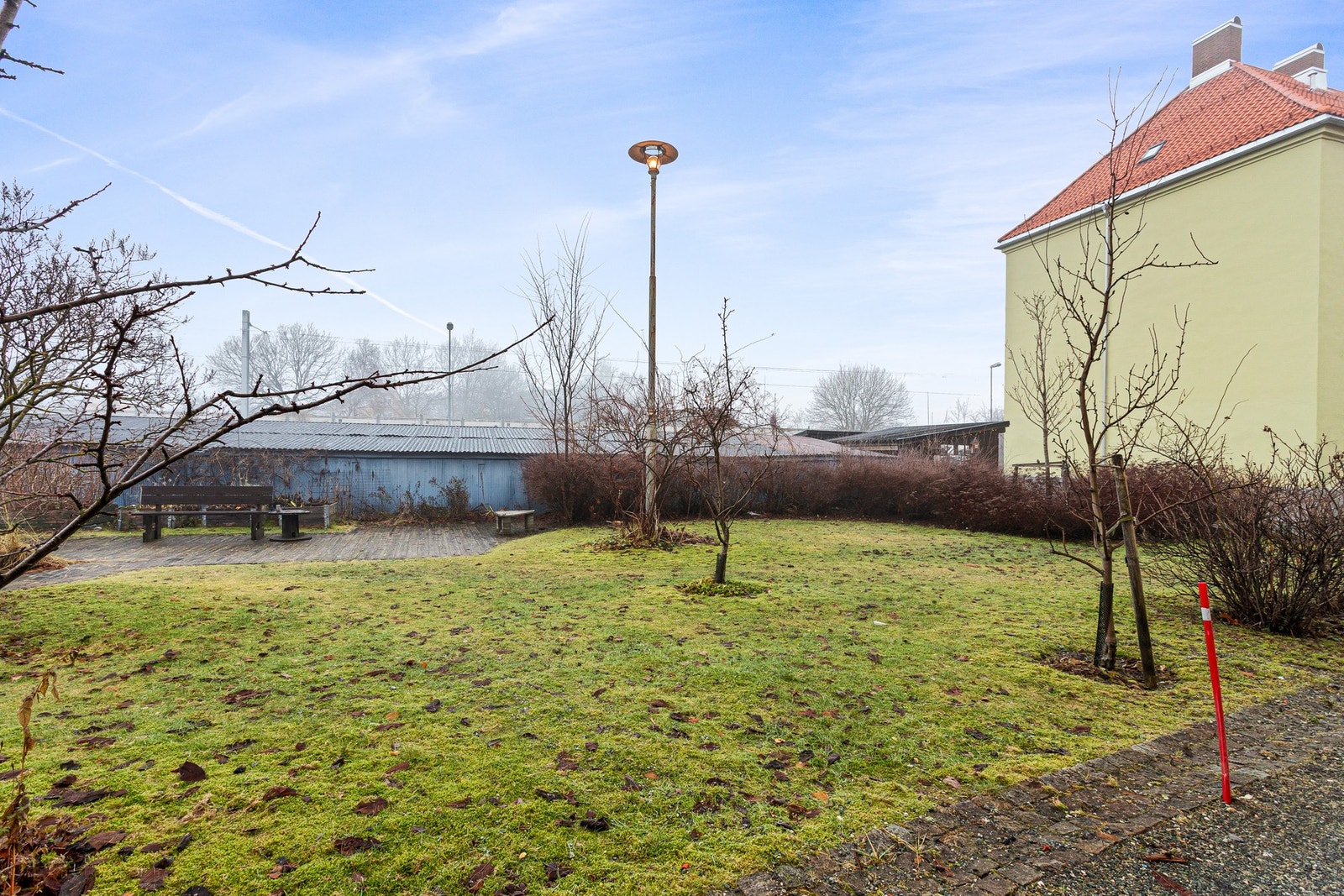 Felles gårdsrom med grøntområder og benker, som gir beboerne et hyggelig uteareal. Galleribilde