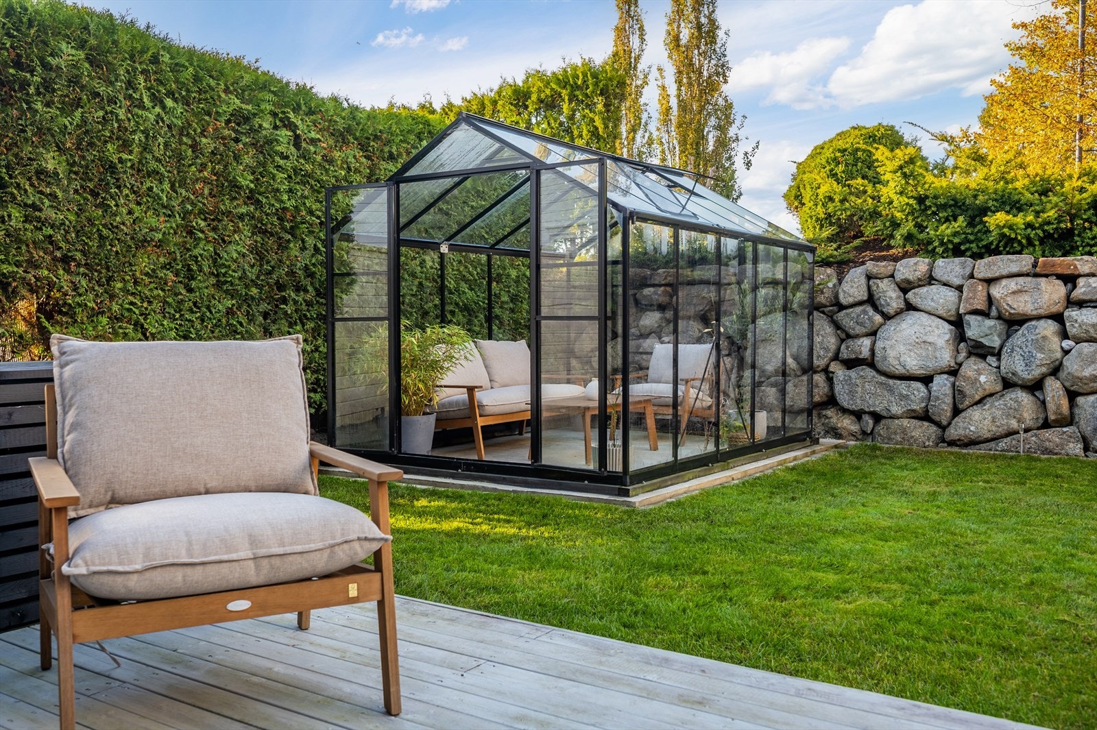 Uteområdet består av terrasse, plen og et drivhus. Galleribilde