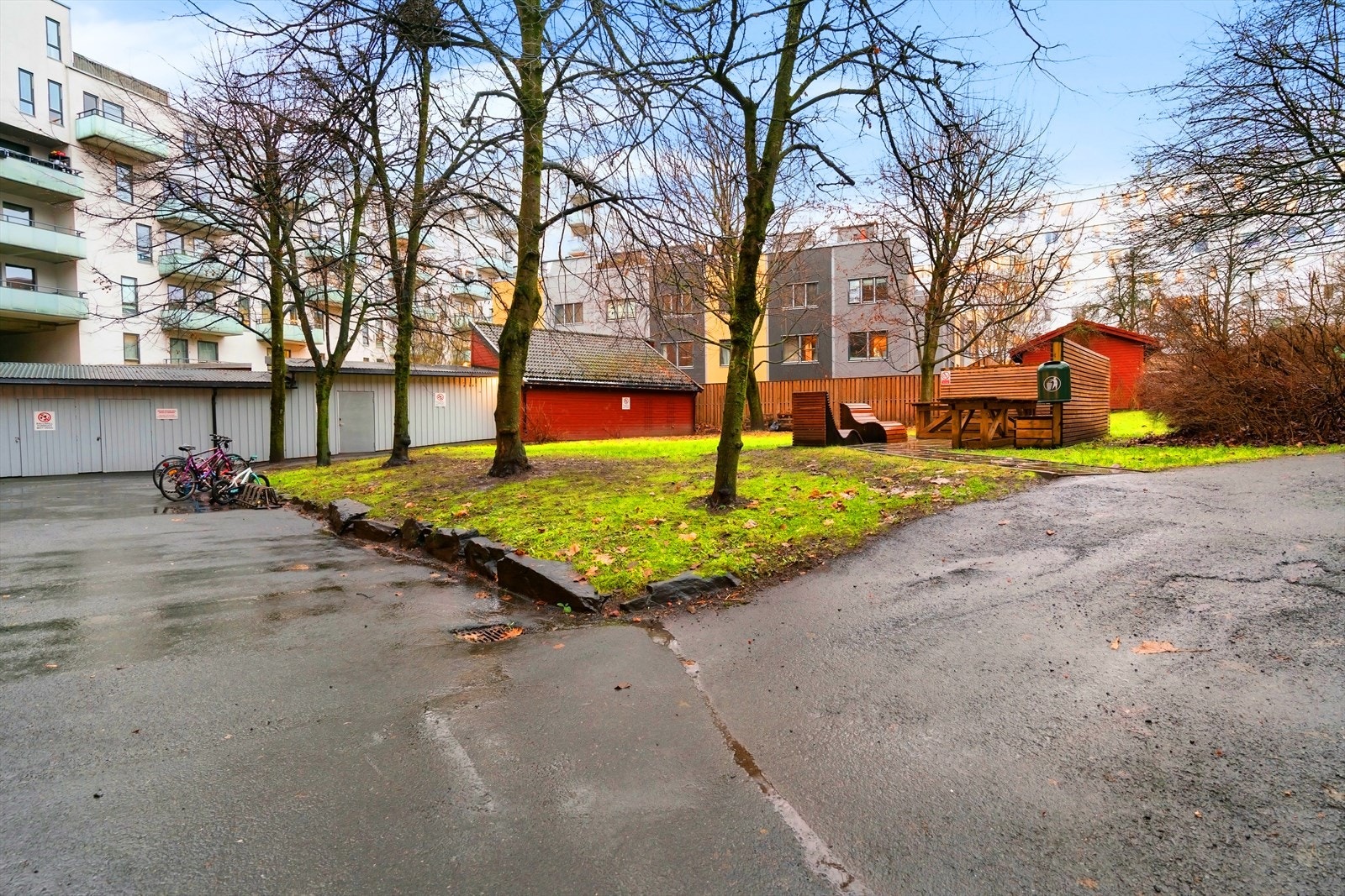 Hyggelig bakgård med plen, sittegrupper, lekeapparater og sykkelparkering. Galleribilde