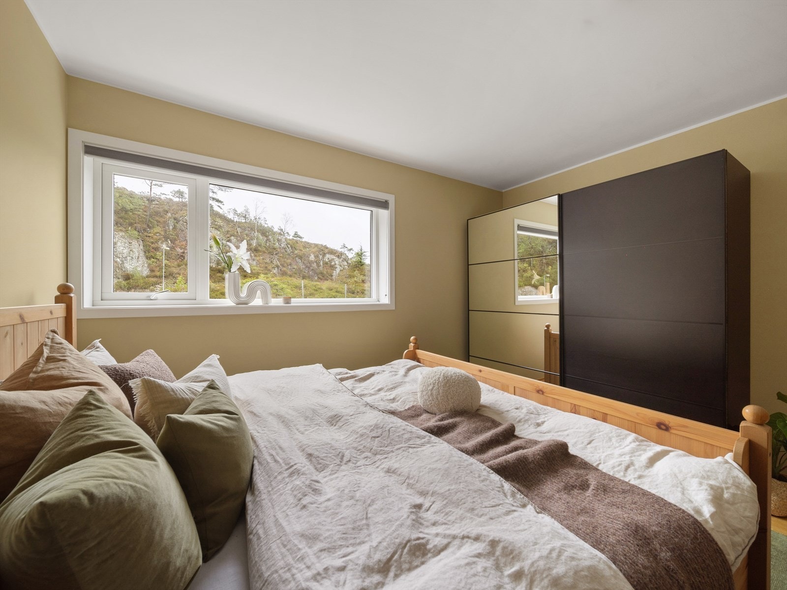 Utsyn mot grøntområde gir en rolig atmosfære i soverommet. Galleribilde