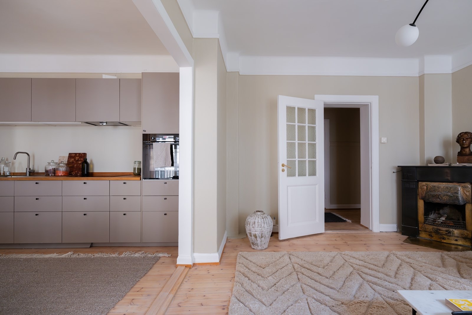 De originale tregulvene får frem det klassiske preget i en ellers lys og romslig leilighet Galleribilde