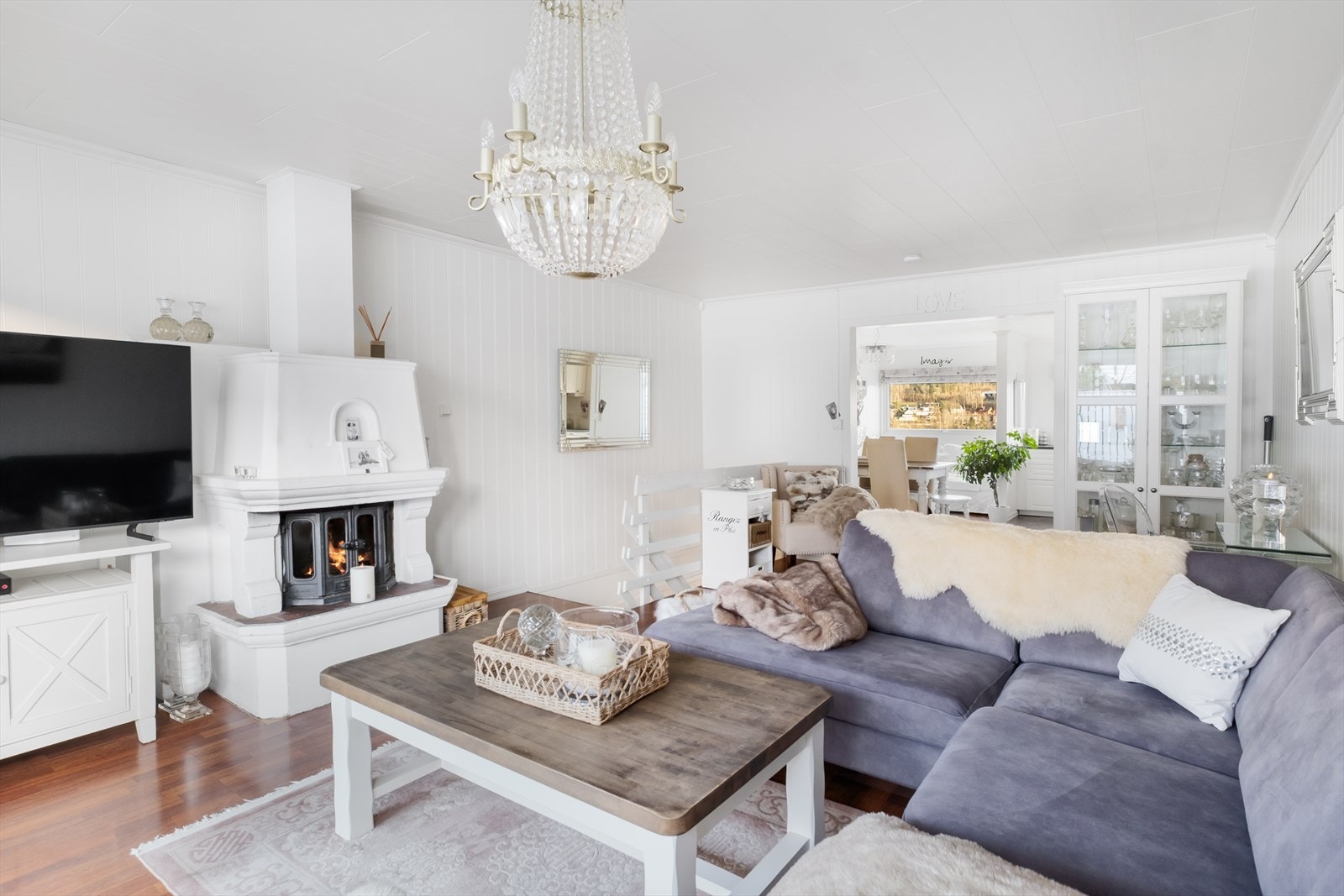 Lys og innbydende stue med elegant og koselig peis. Moderne design skaper et rom med perfekt balanse mellom hygge og stilrent uttrykk Galleribilde