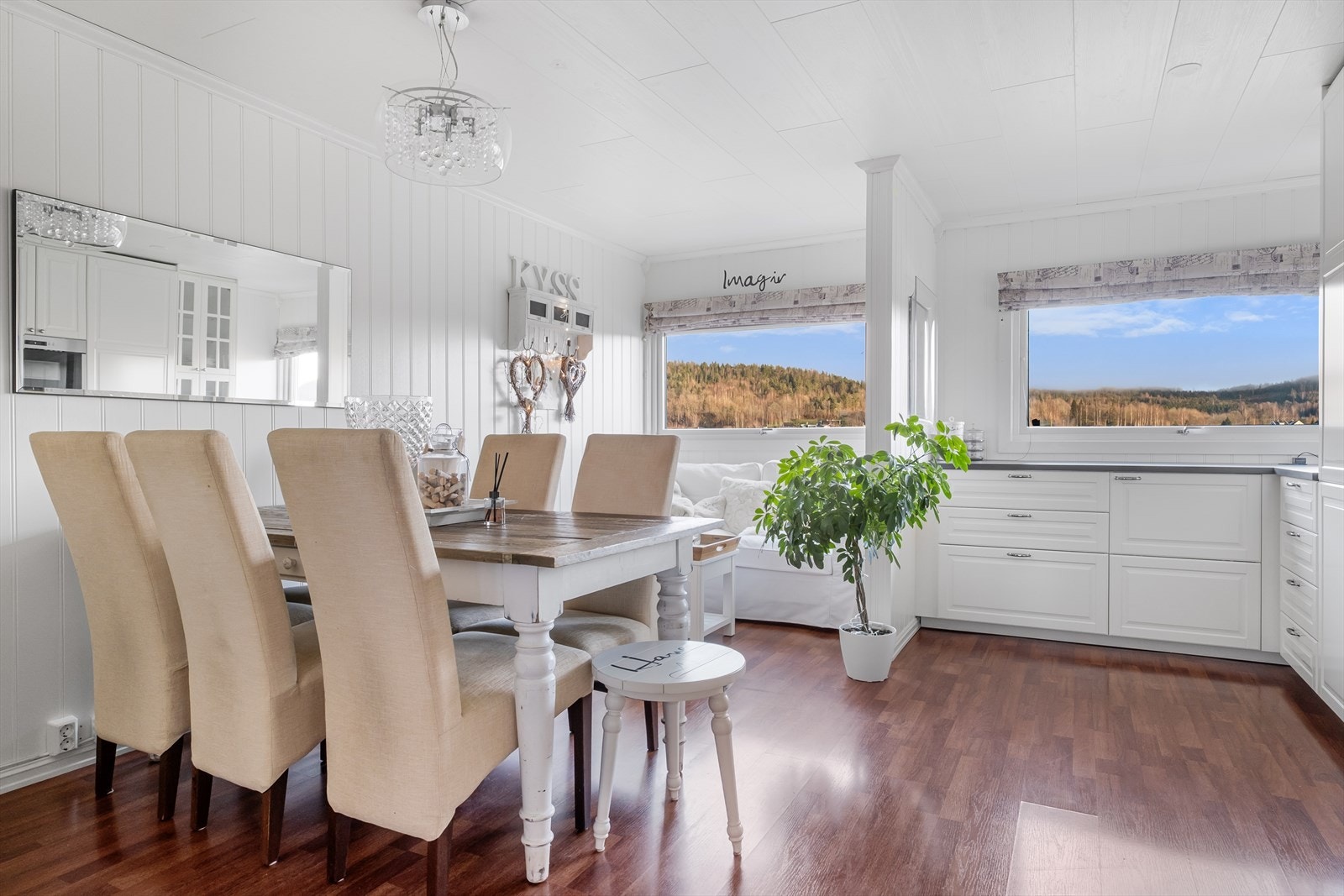 Lyst og trivelig kjøkken- og spiseområde med store vinduer som slipper inn rikelig med dagslys Galleribilde