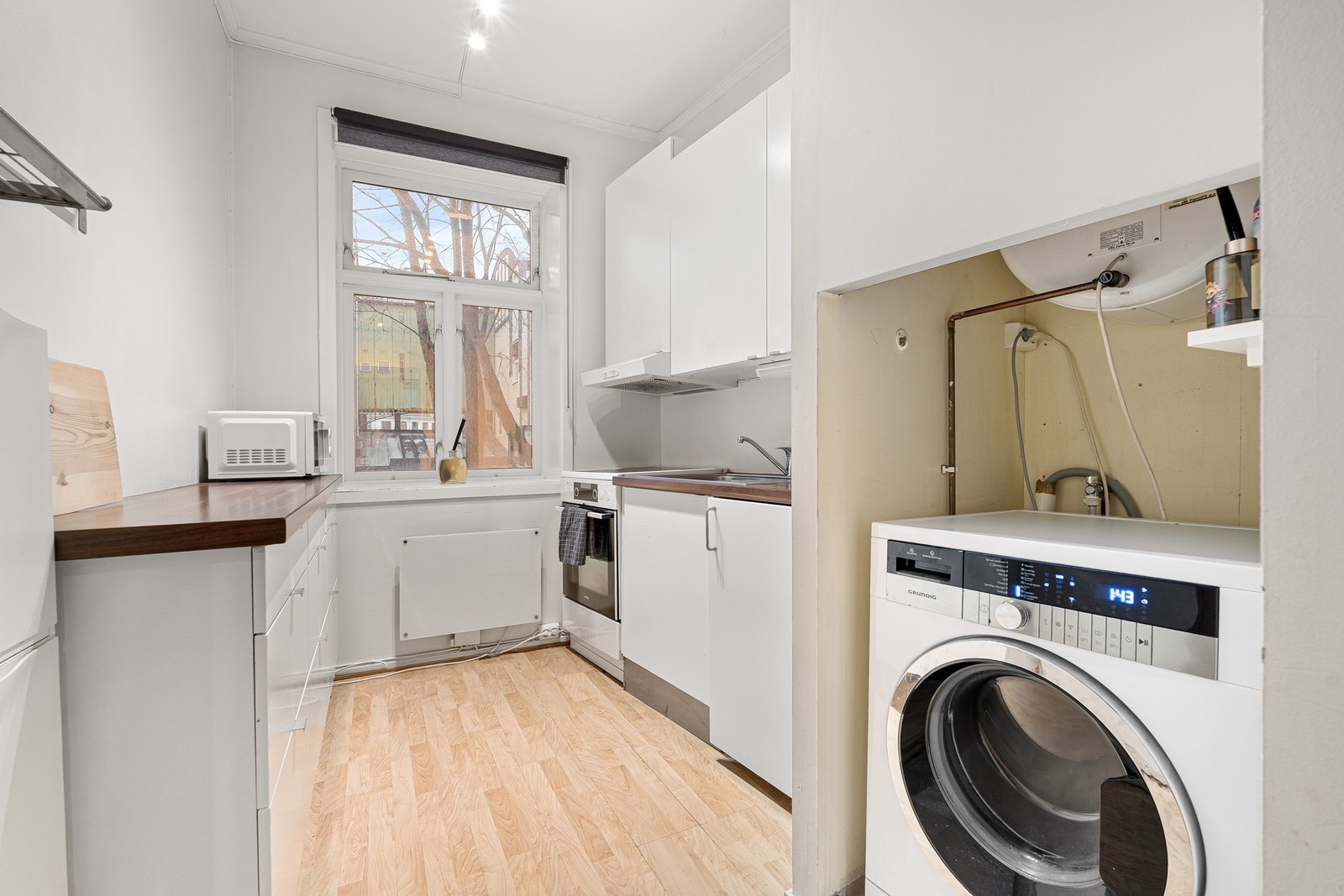 Lyst kjøkken med smart planløsning og plass til nødvendige hvitevarer. Galleribilde