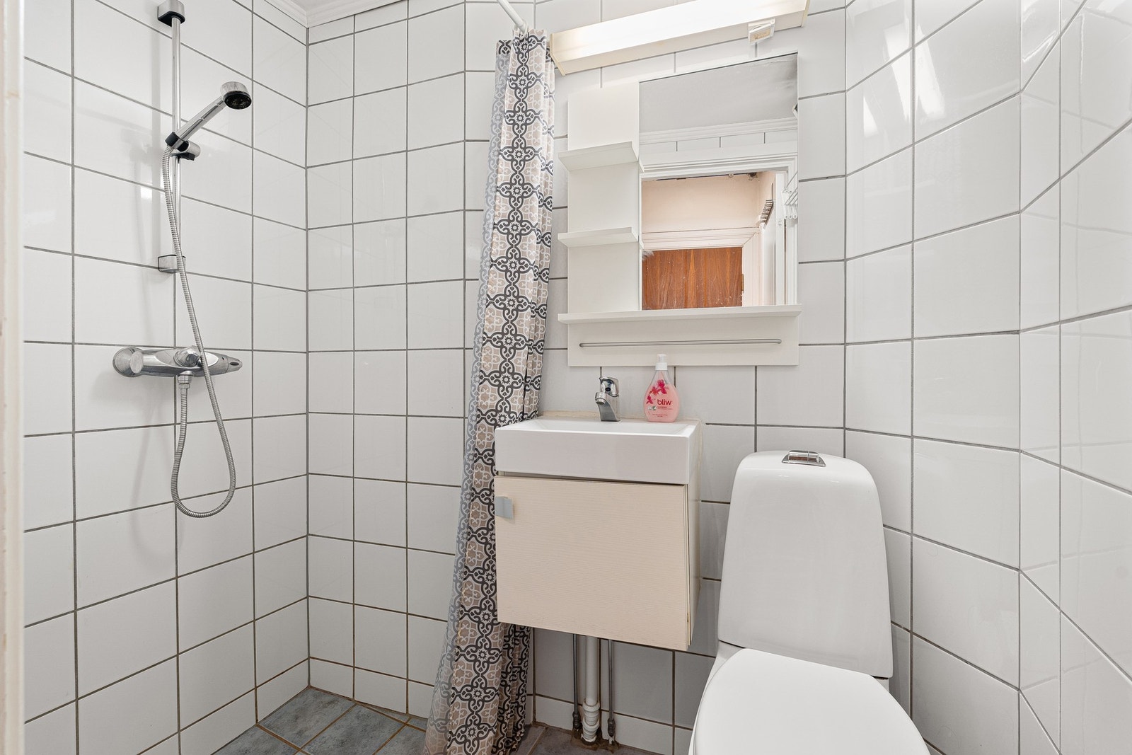 Lyst flislagt bad med varmeradiator. Galleribilde