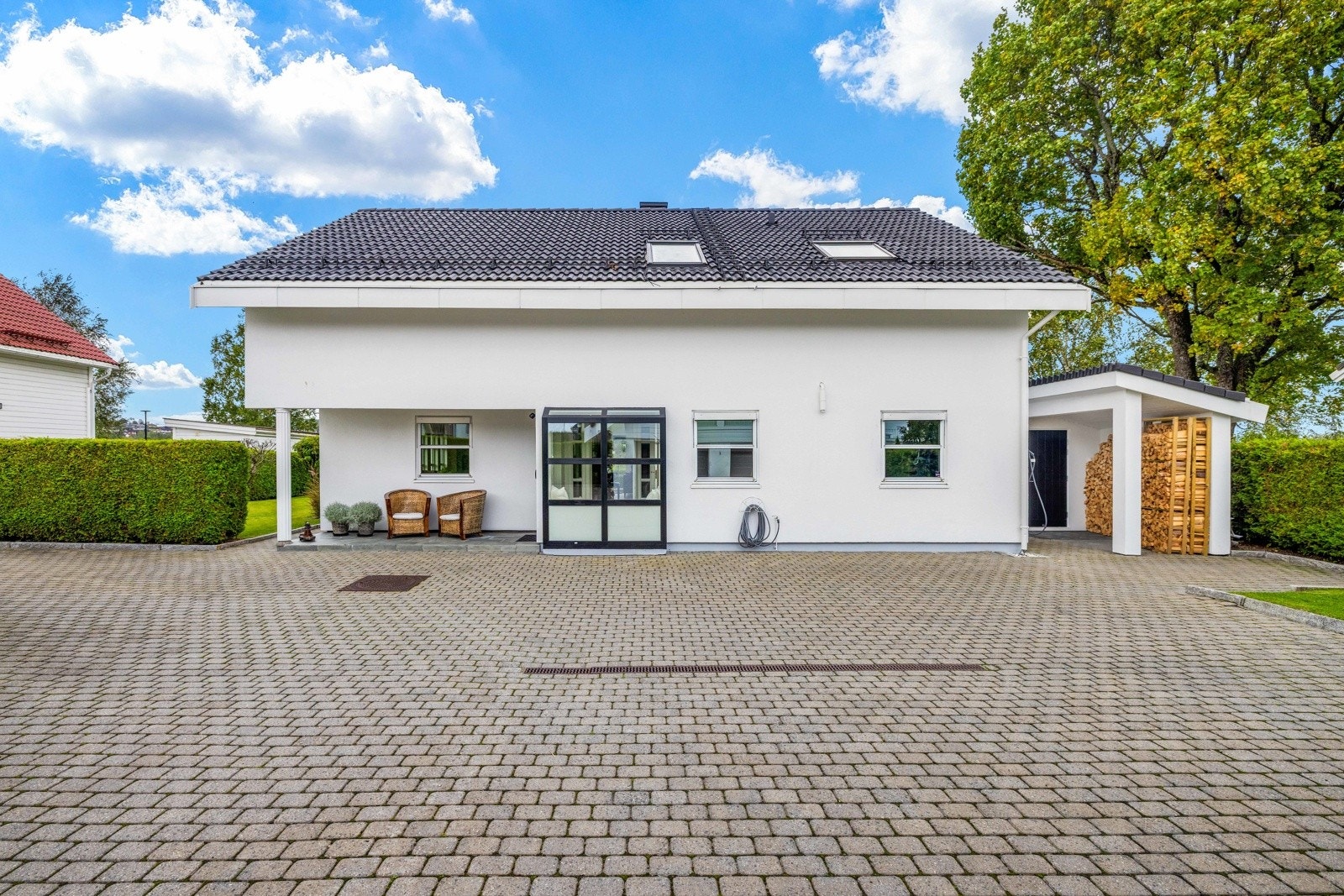 Foran boligen er det stor og steinlagt gårdsplass med gode parkeringsmuligheter. Dobbelgarasje med hybel (ikke godkjent). Galleribilde