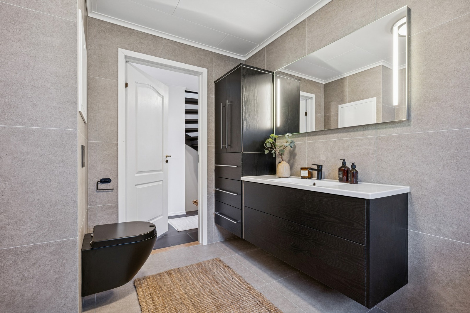 Innredningen består av servantinnredning, dusjhjørne med glassdører, vegghengt toalett samt opplegg for vaskemaskin. Galleribilde