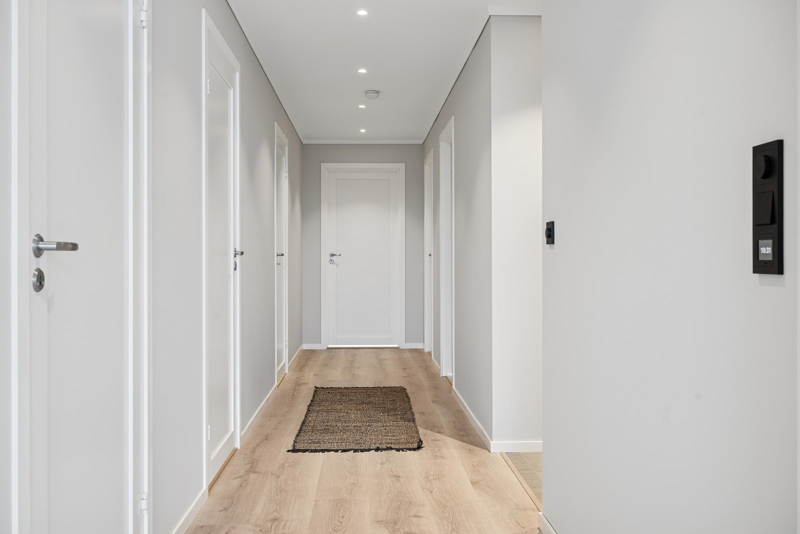 Entréen ønsker velkommen med elegant laminat og moderne spotter som gir et stilrent preg. Galleribilde