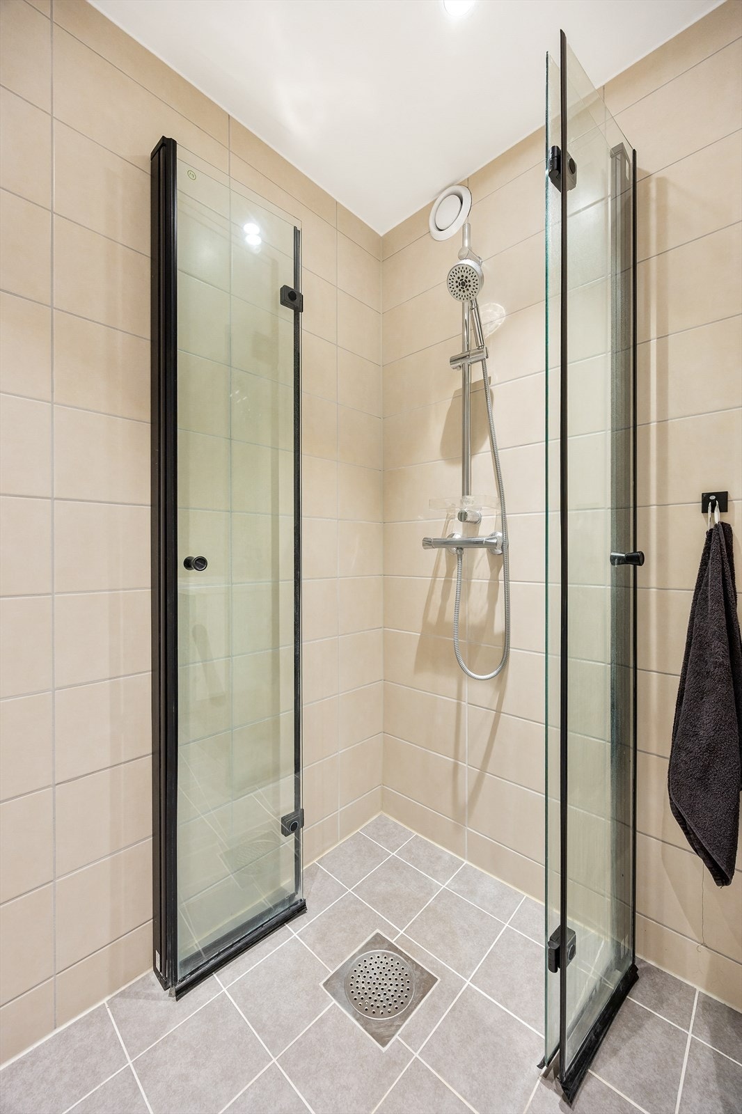 Her er det et praktisk dusjhjørne med innfellbare dører i herdet glass og mekanisk avtrekk. Galleribilde