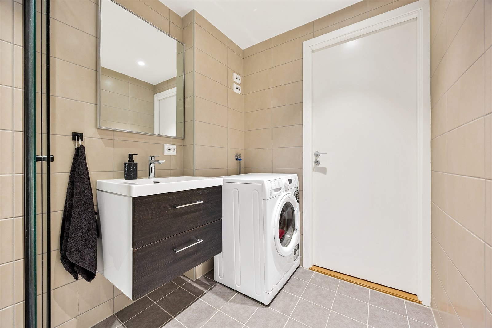 Badet har servant med underskap, varmekabler i gulvet og opplegg for vaskemaskin. Galleribilde