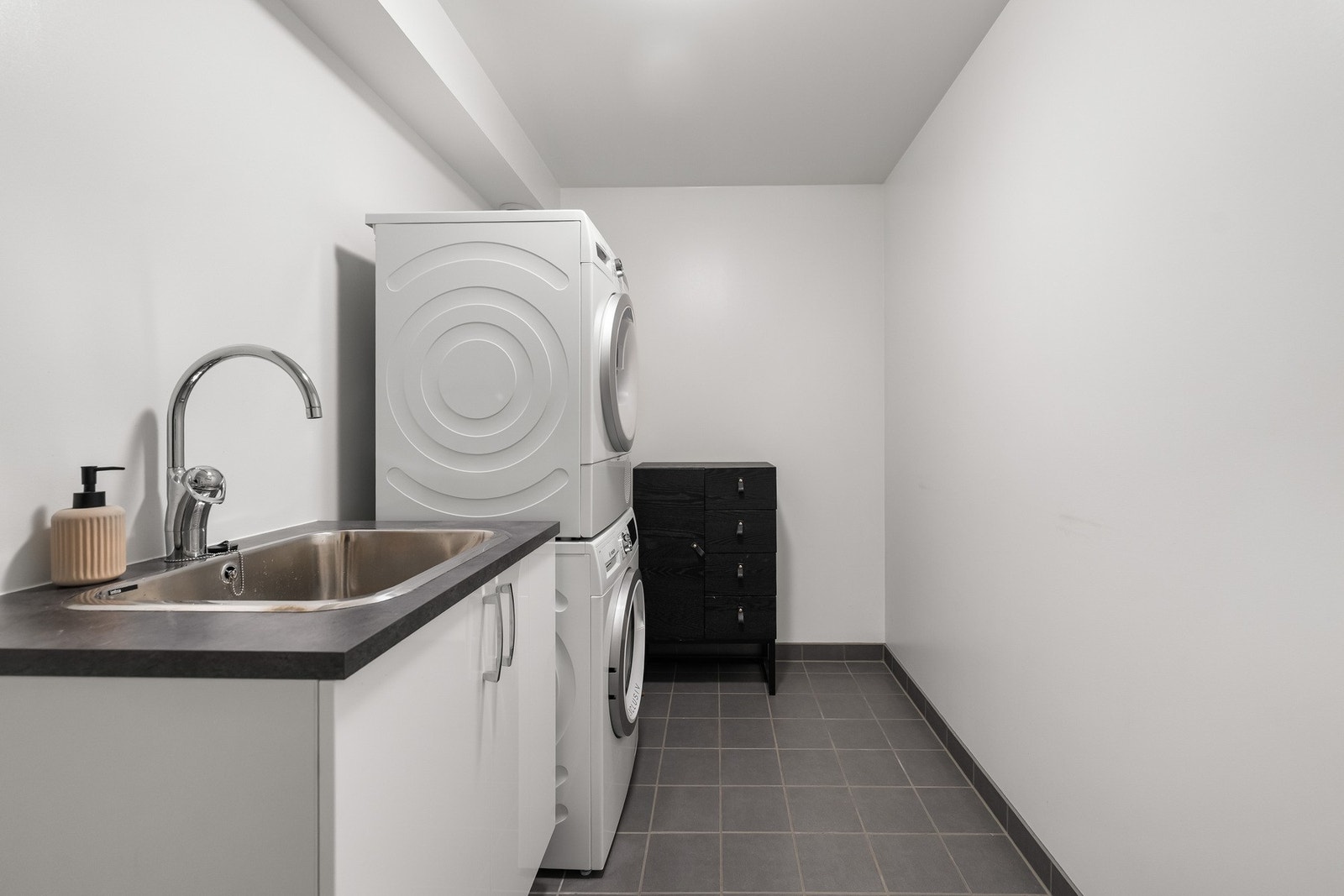 Praktisk og romslig vaskerom med opplegg for vaskemaskin og tørketrommel. Galleribilde