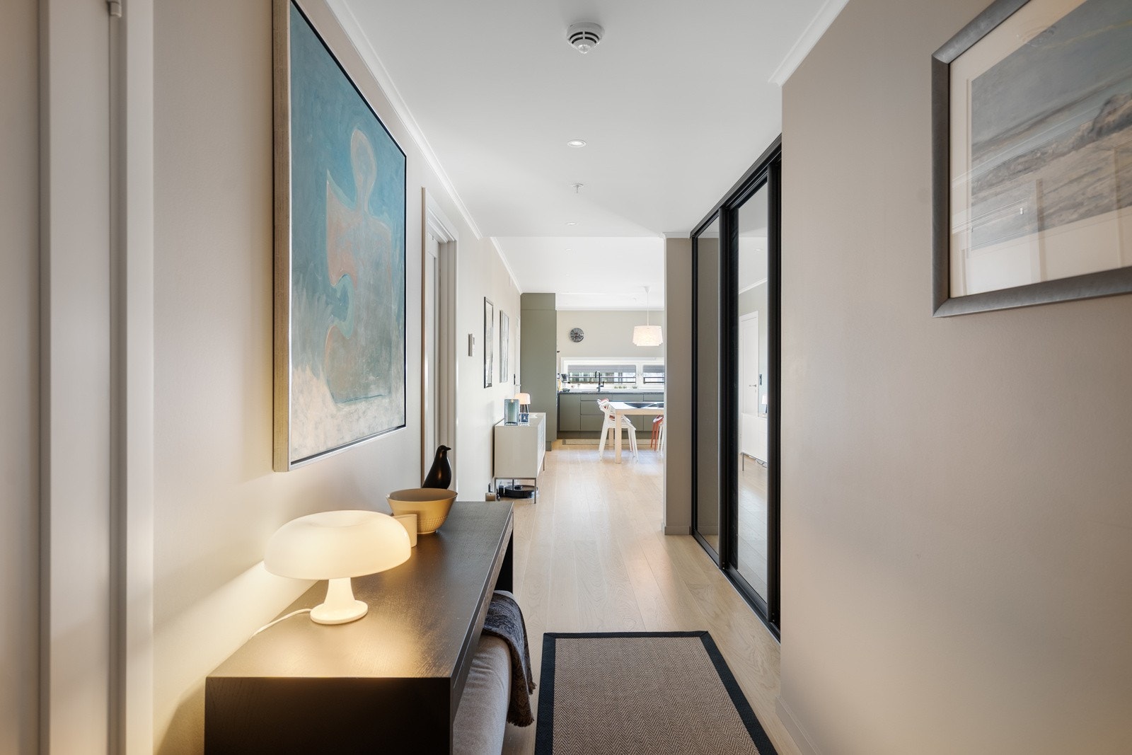 Lys og innbydende entré med stor skyvedørsgarderobeskap m/ speil Galleribilde