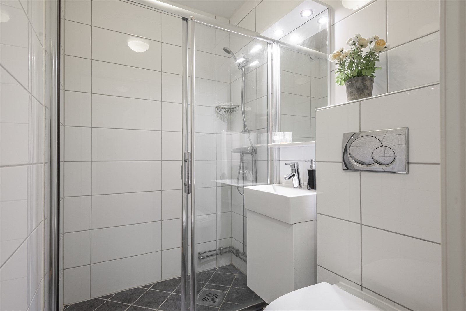 Lyst og tidløst bad (2011) med flislagt gulv og vegger. Det er gulvvarme. Galleribilde