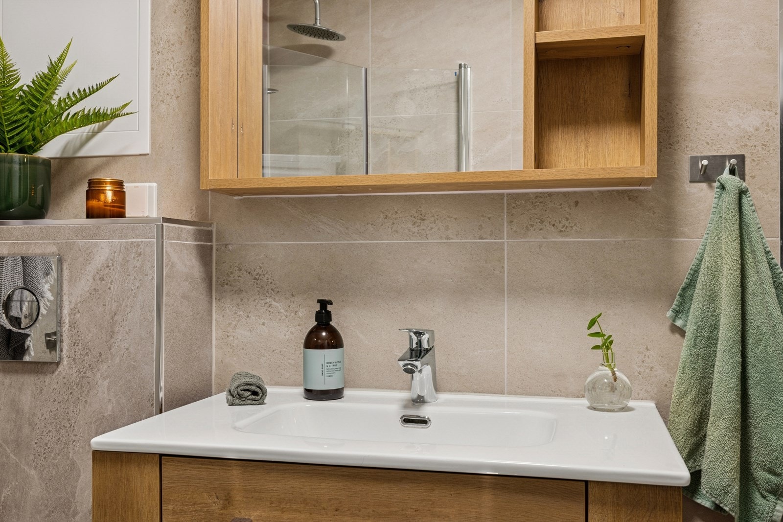 Badet fremstår som moderne og delikat, med lyse fliser og en tidløs utforming. Galleribilde