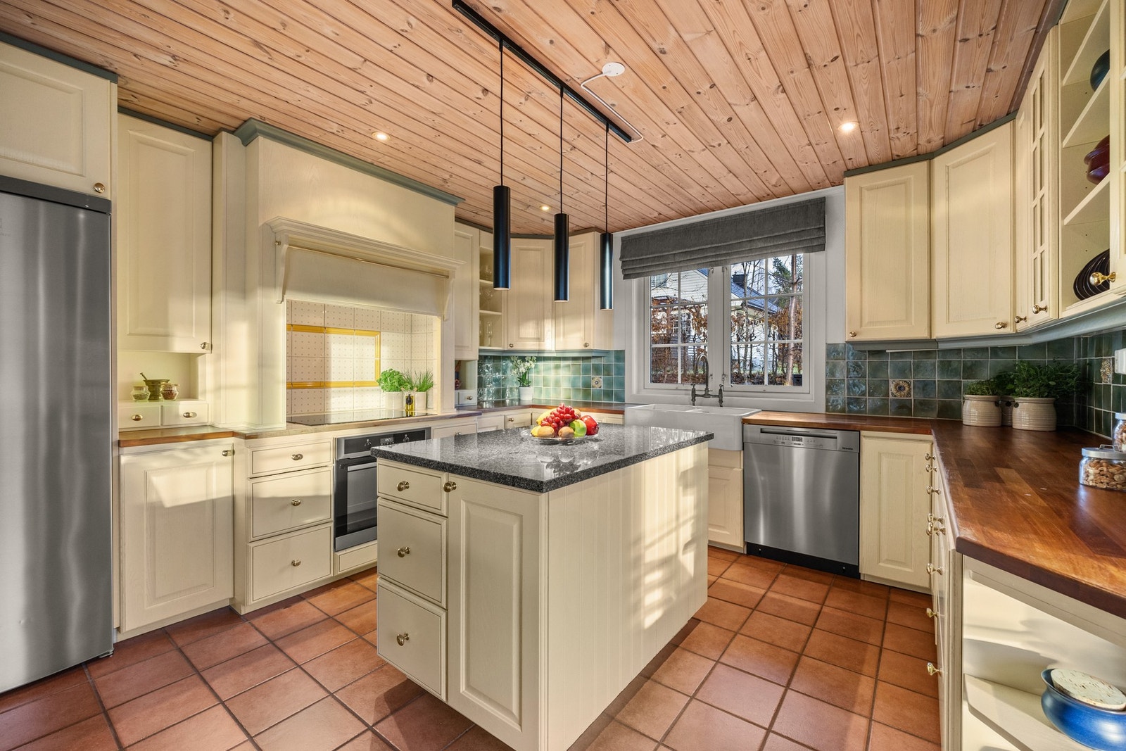 Lyst og funksjonelt kjøkken med gode skap- og benkeplasser Galleribilde